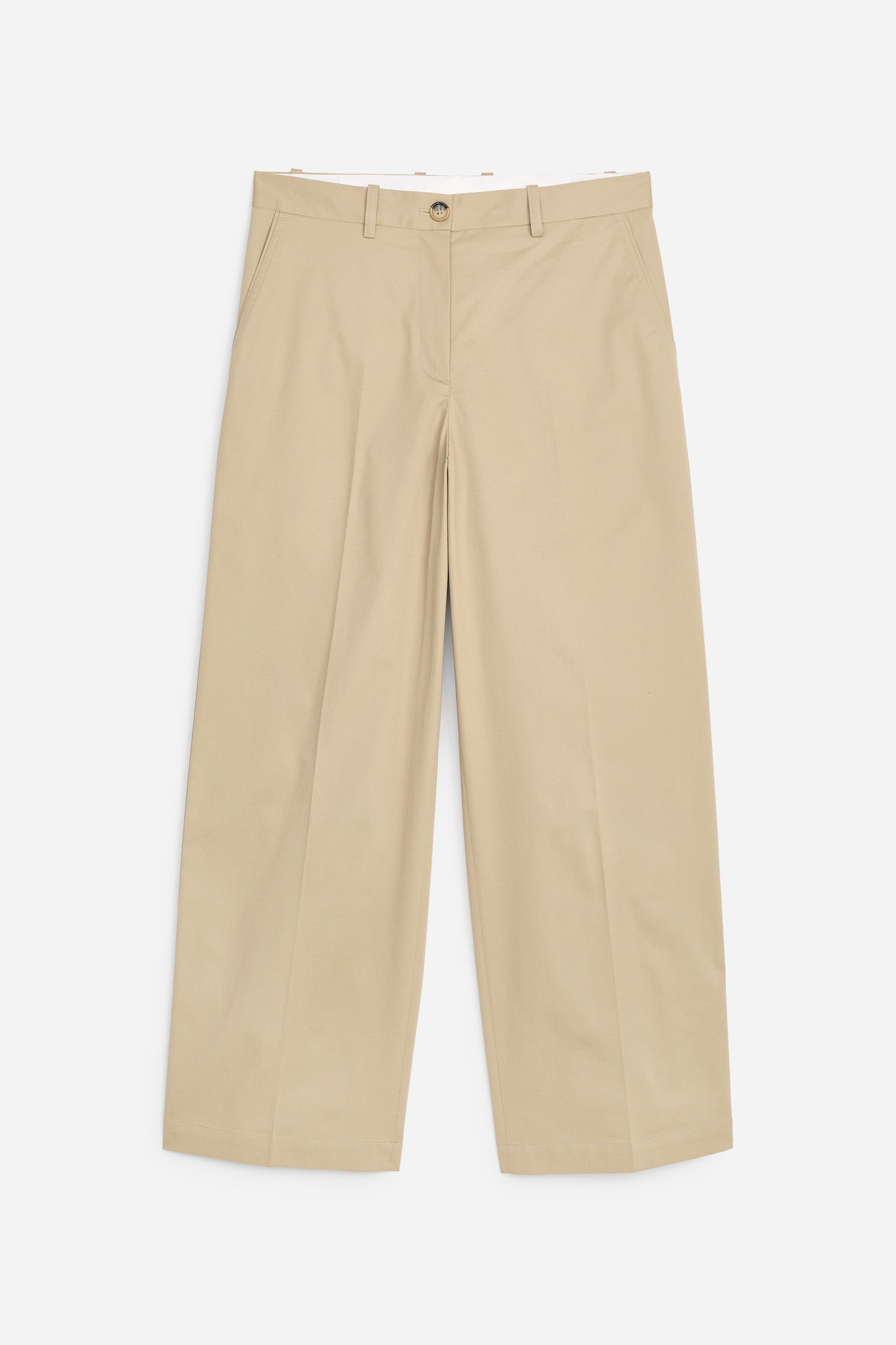 Grösseres Bild ansehen: Beige weite Hosen mit weitem Bein sind von vorne zu sehen und zeigen einen Knopfverschluss, Gürtelschlaufen und schräge Seitentaschen. Die verkürzten Beine weisen markante vordere Bügelfalten auf.
