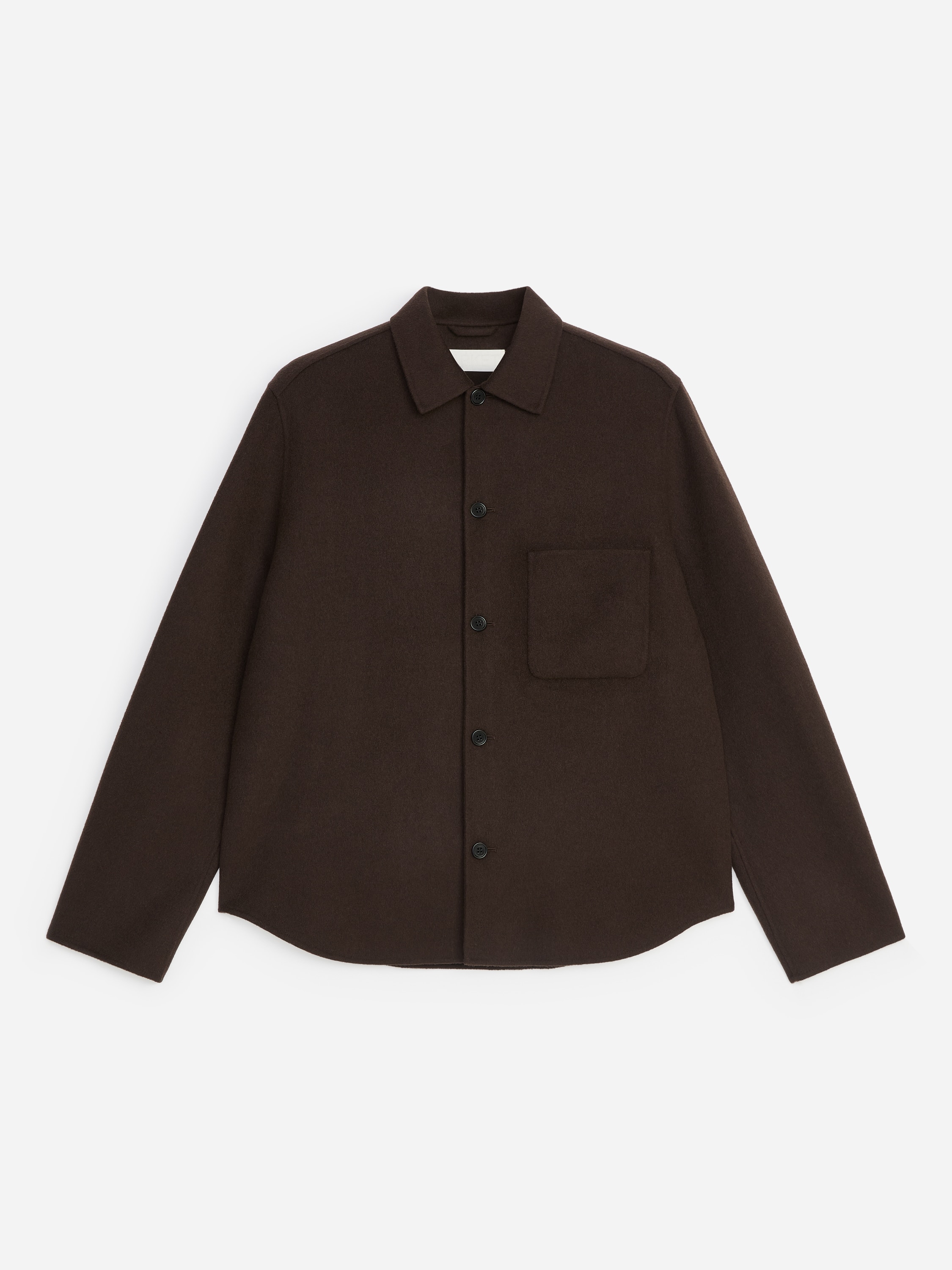 A modelo veste uma overshirt em mistura de lÃ£ castanho-escura, com gola clÃ¡ssica, fecho frontal por botÃµes e um Ãºnico bolso de chapa no peito. A overshirt estruturada Ã© usada sobre um top a condizer e combinada com calÃ§as de perna larga a condizer.
