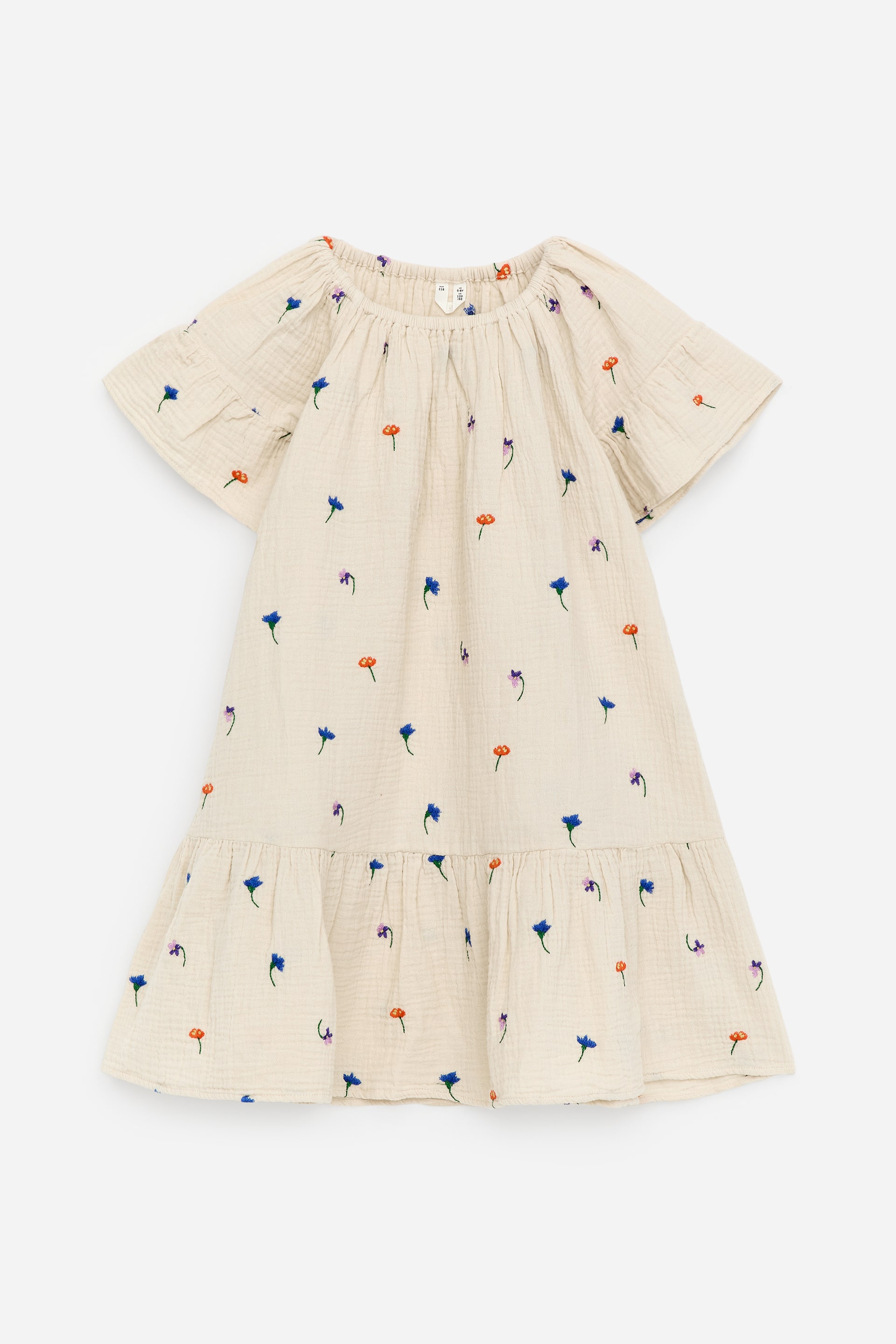 Agrandir l'image: Une robe de couleur crème présente une texture froissée et une broderie florale éparse dans des teintes de bleu, orange et violet. Elle est conçue avec un col rond froncé, des manches courtes évasées et un volant froncé près du bas.