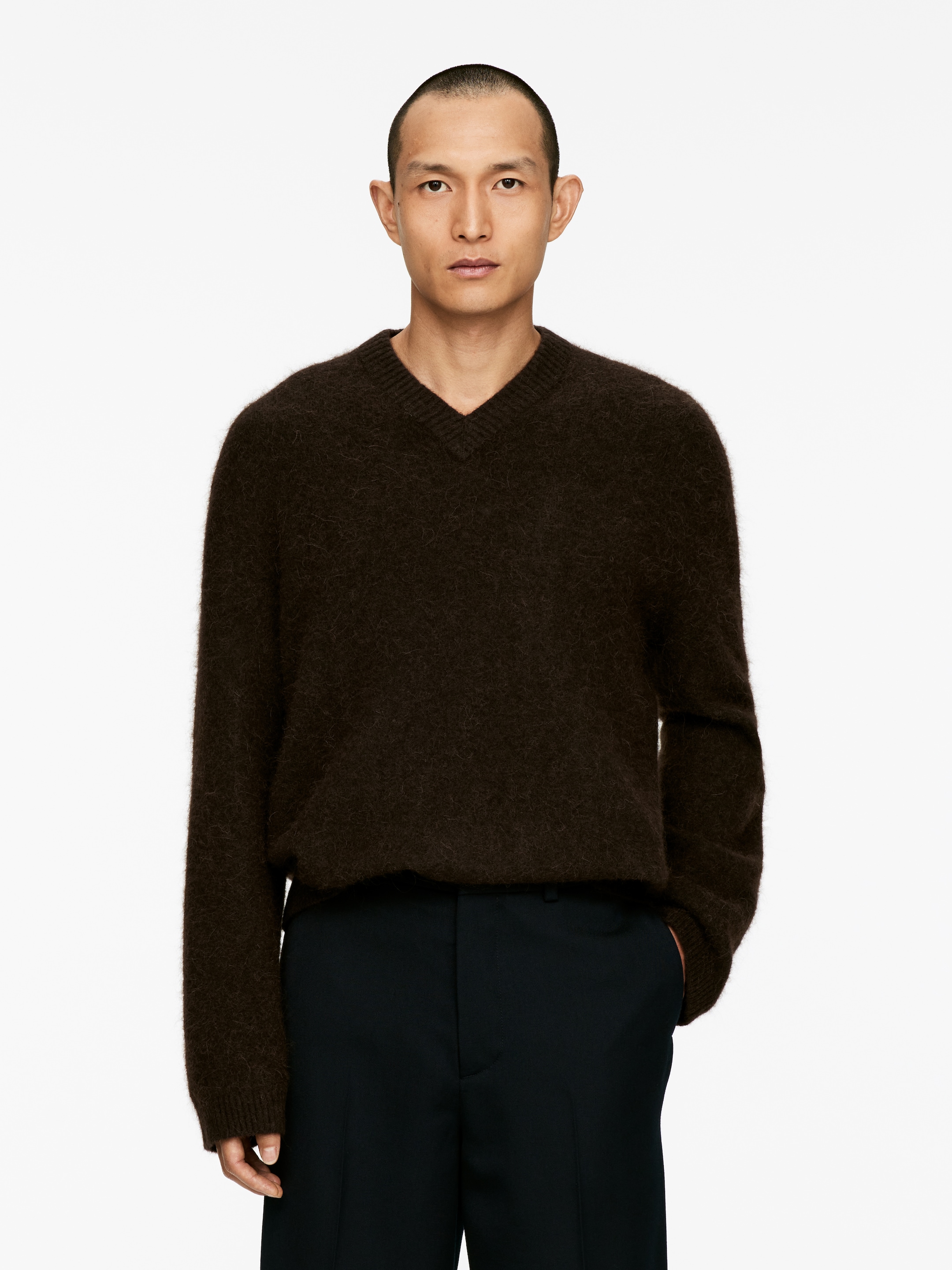 Agrandir l'image: Un pull à col en V marron foncé, vu de face, présente une texture duveteuse, une coupe décontractée, ainsi que des poignets et un ourlet côtelés.