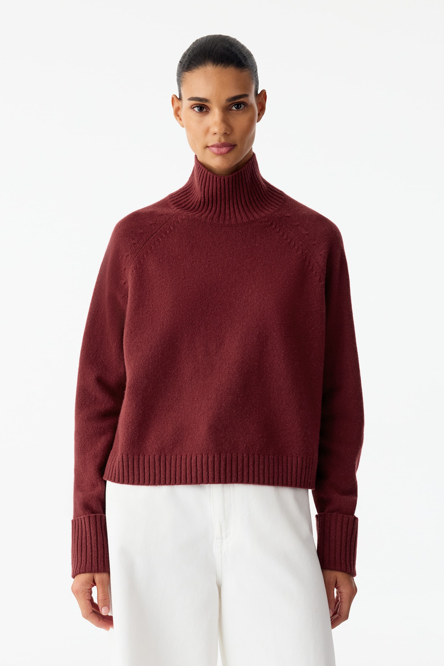 Questo pullover lavorato a maglia bordeaux, visto frontalmente, presenta un collo alto a coste con piccolo spacco sul retro, maniche raglan e polsini ripiegati a coste. Il capo ha una vestibilitÃ  classica e un orlo a coste. - 1