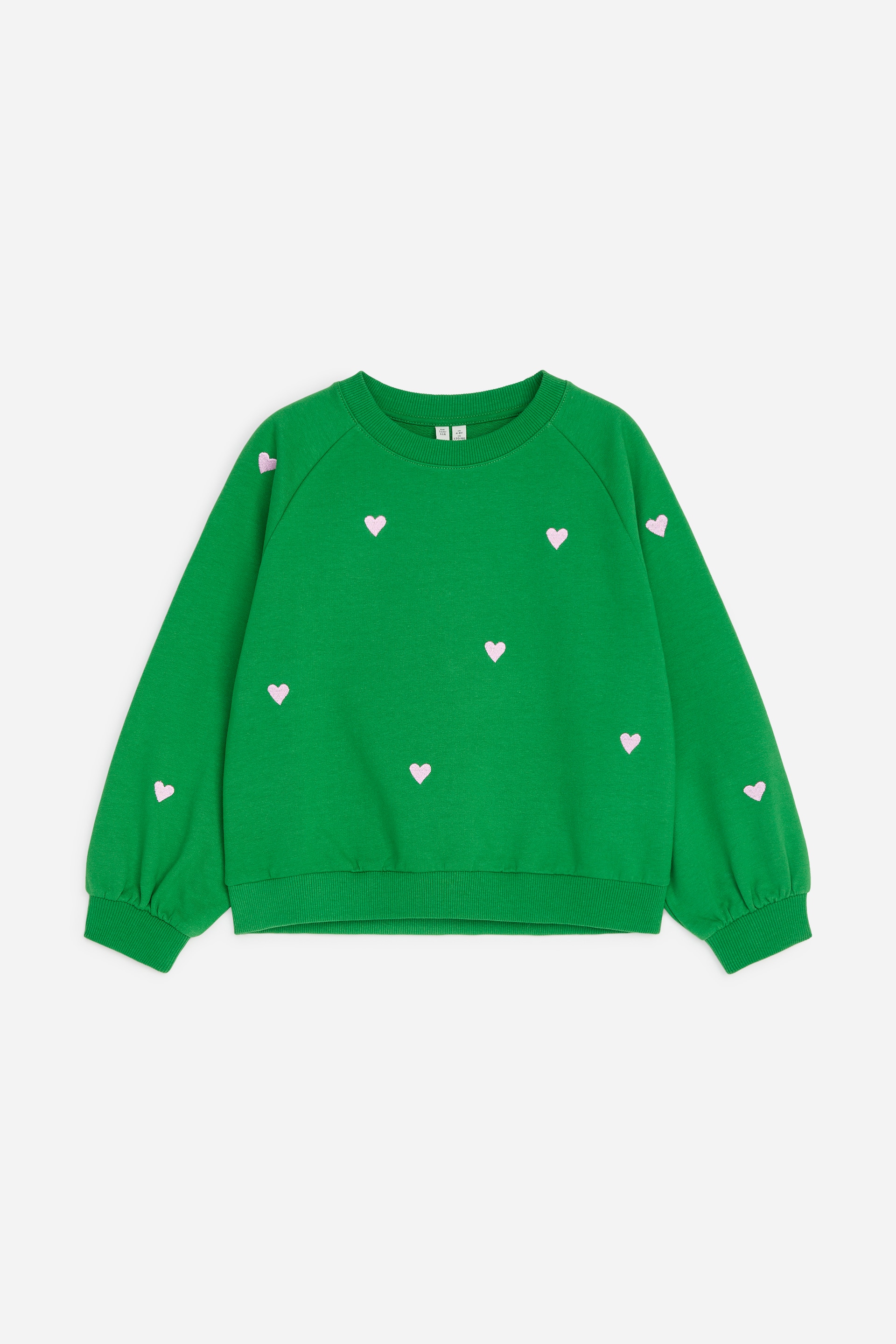View larger image: A green sweatshirt is showcased facing front, featuring a ribbed crew neck. It is adorned with scattered light pink heart motifs and boasts long raglan sleeves with gathering at the ribbed cuffs, concluding with a ribbed hem.