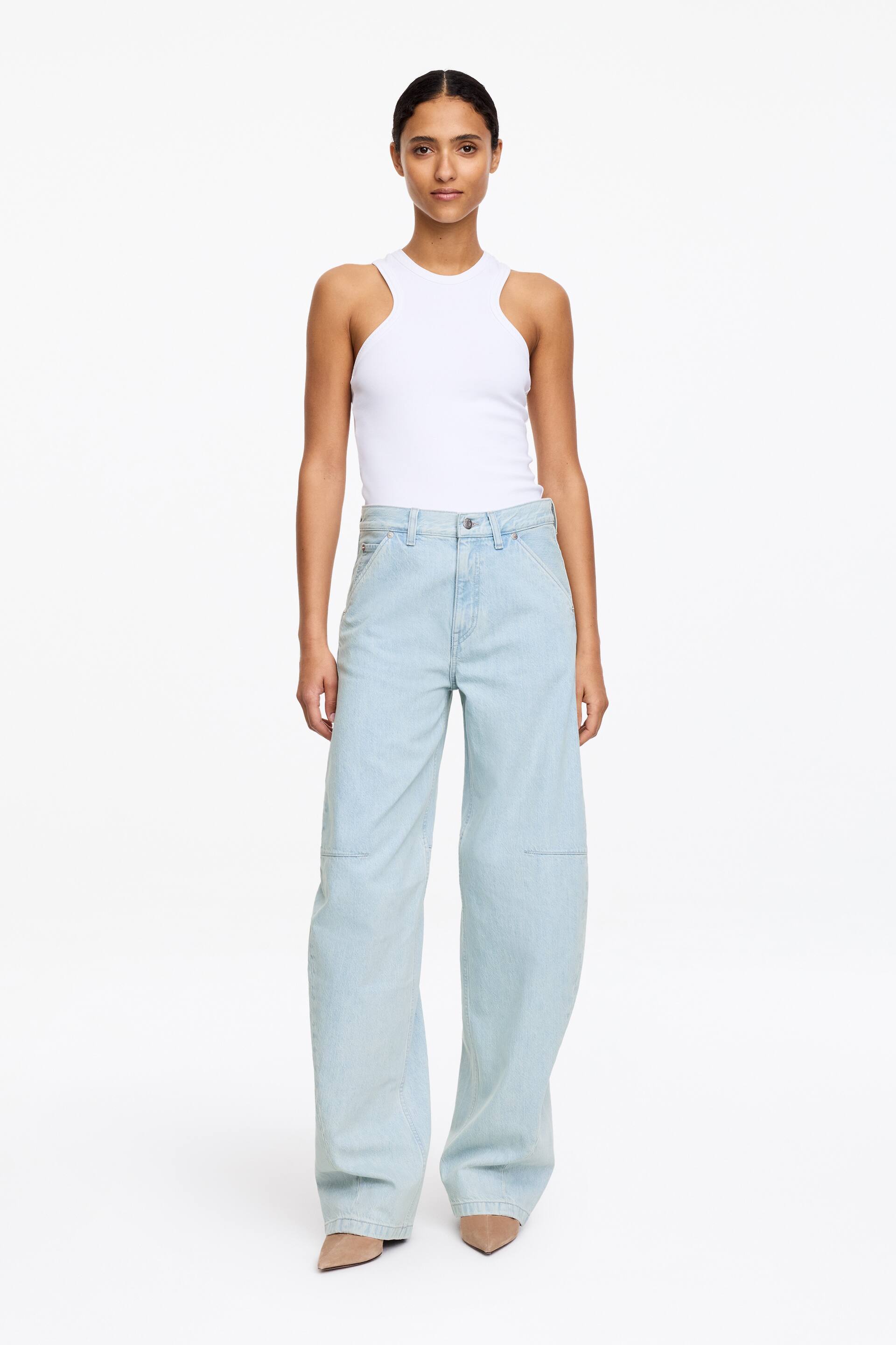Agrandir l'image: Jeans bleu clair à jambes larges, offrant une coupe décontractée avec des poches utilitaires à l'avant et des coutures rectangulaires sur les panneaux des genoux. Les jeans présentent une silhouette pleine longueur, vue de face.