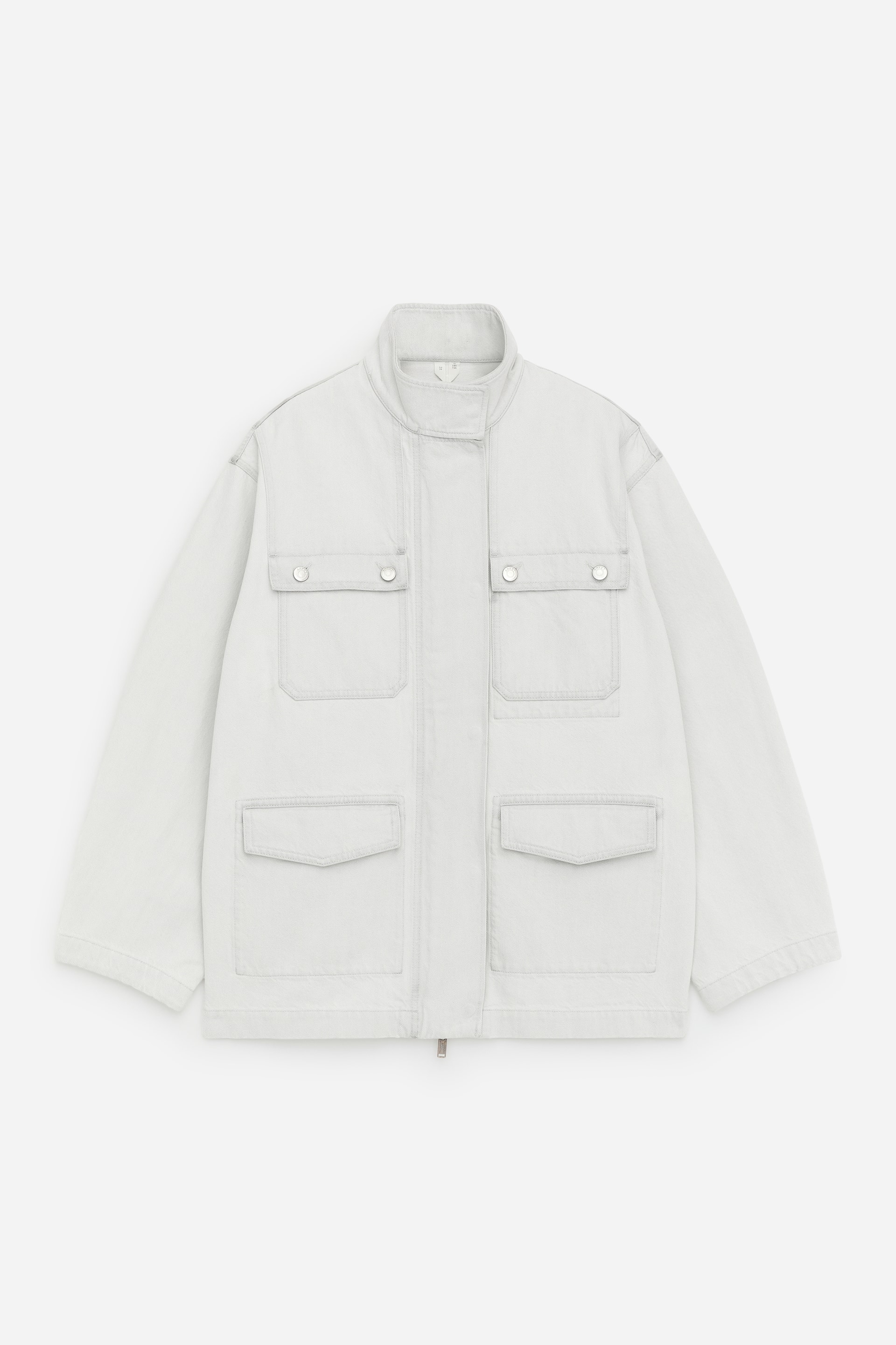 Ingrandisci l'immagine: Giacca grigio chiaro vista FRONTALE. Presenta un colletto a fascia, una chiusura con cerniera nascosta sul davanti, due tasche sul petto con patta e bottoni a pressione argentati, e due ampie tasche inferiori con patta.