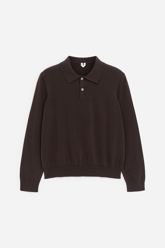Ein dunkelbraunes, langärmliges Poloshirt präsentiert seine Vorderseite, mit einem klassischen Polokragen, einer Knopfleiste mit zwei hellen Knöpfen sowie gerippten Bündchen und Saum. - 1