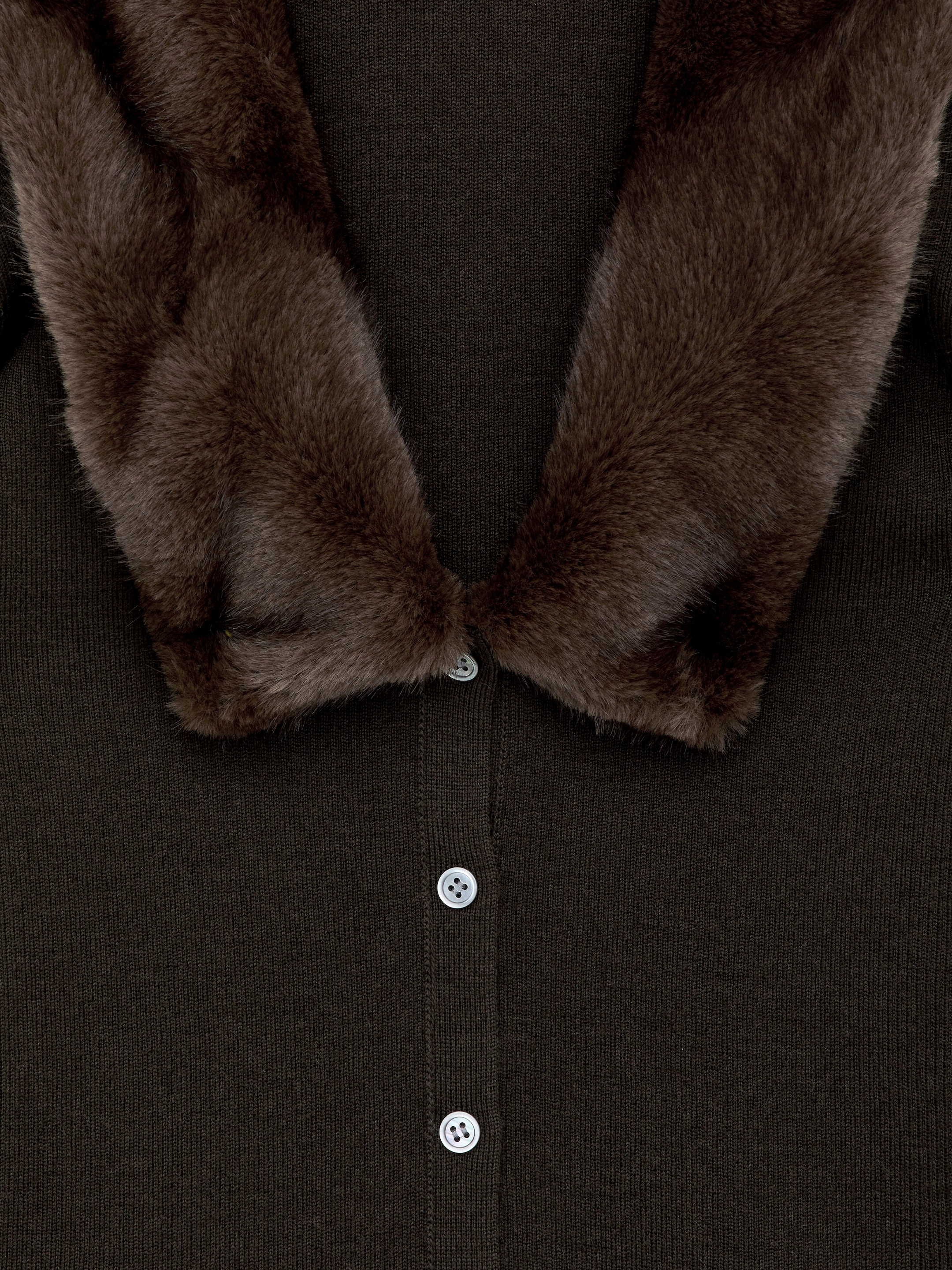 Agrandir l'image: Un cardigan en tricot brun foncé est présenté de face, avec un col en fausse fourrure brune et une patte de boutonnage centrale avec des boutons blancs.