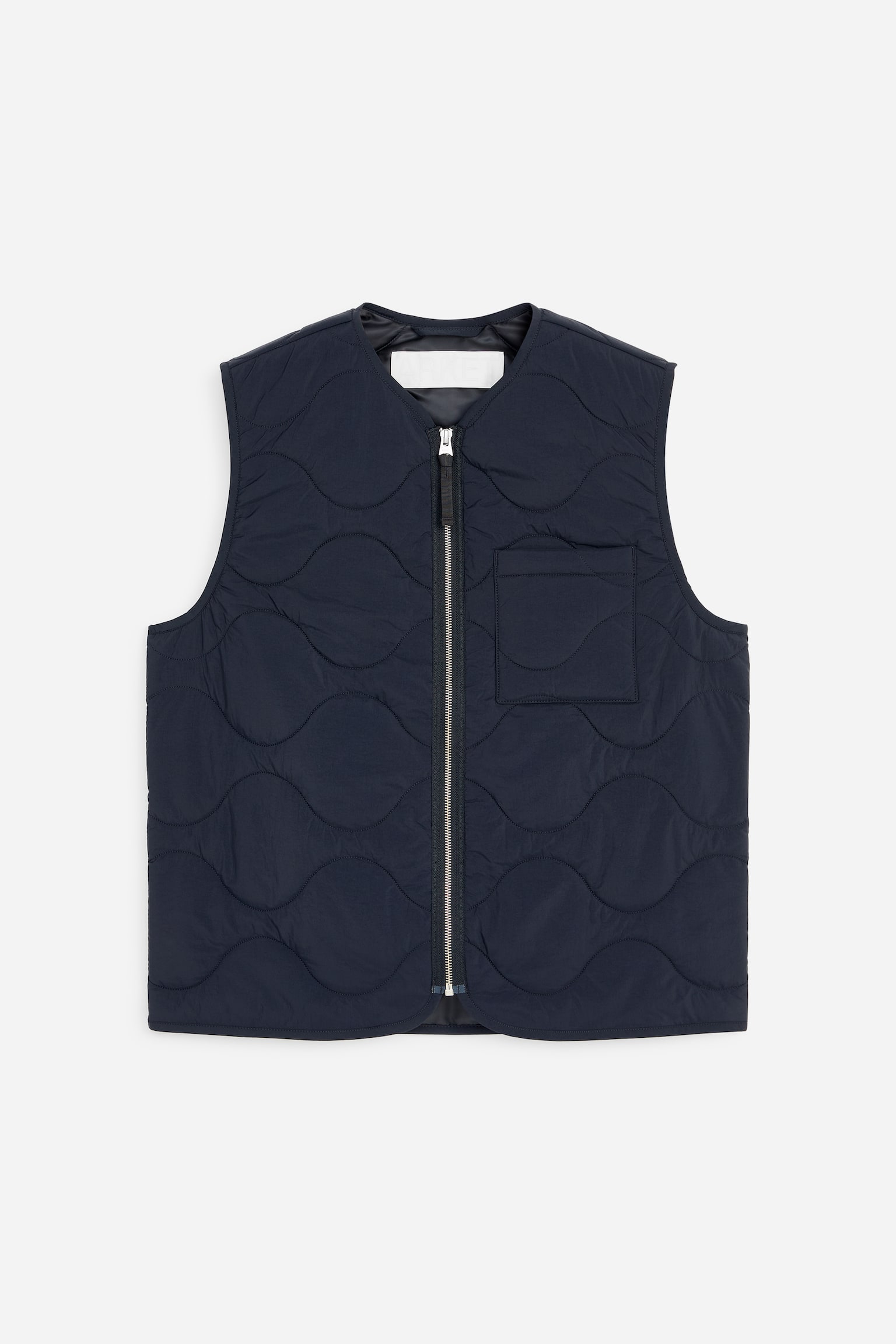 Un gilet matelassé bleu foncé est présenté de face, arborant un motif de surpiqûres en forme d'oignon sur toute la surface. Il est doté d'une fermeture éclair frontale de couleur argentée et d'une poche plaquée sur le côté gauche du porteur. - 1