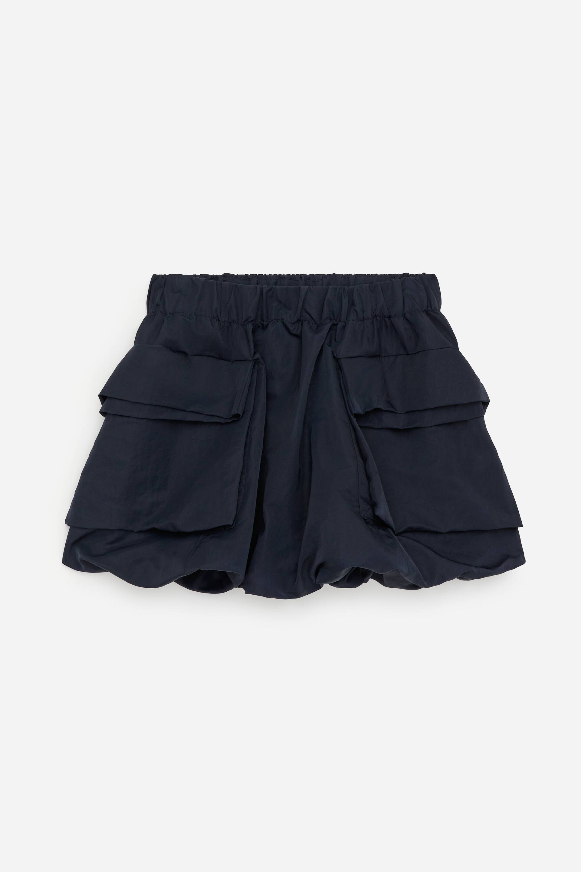 Vis større bilde: En marineblå miniskjørt viser sin FORSIDE, med en elastisk midje, to lagdelte frontlommer og en ballongkant.