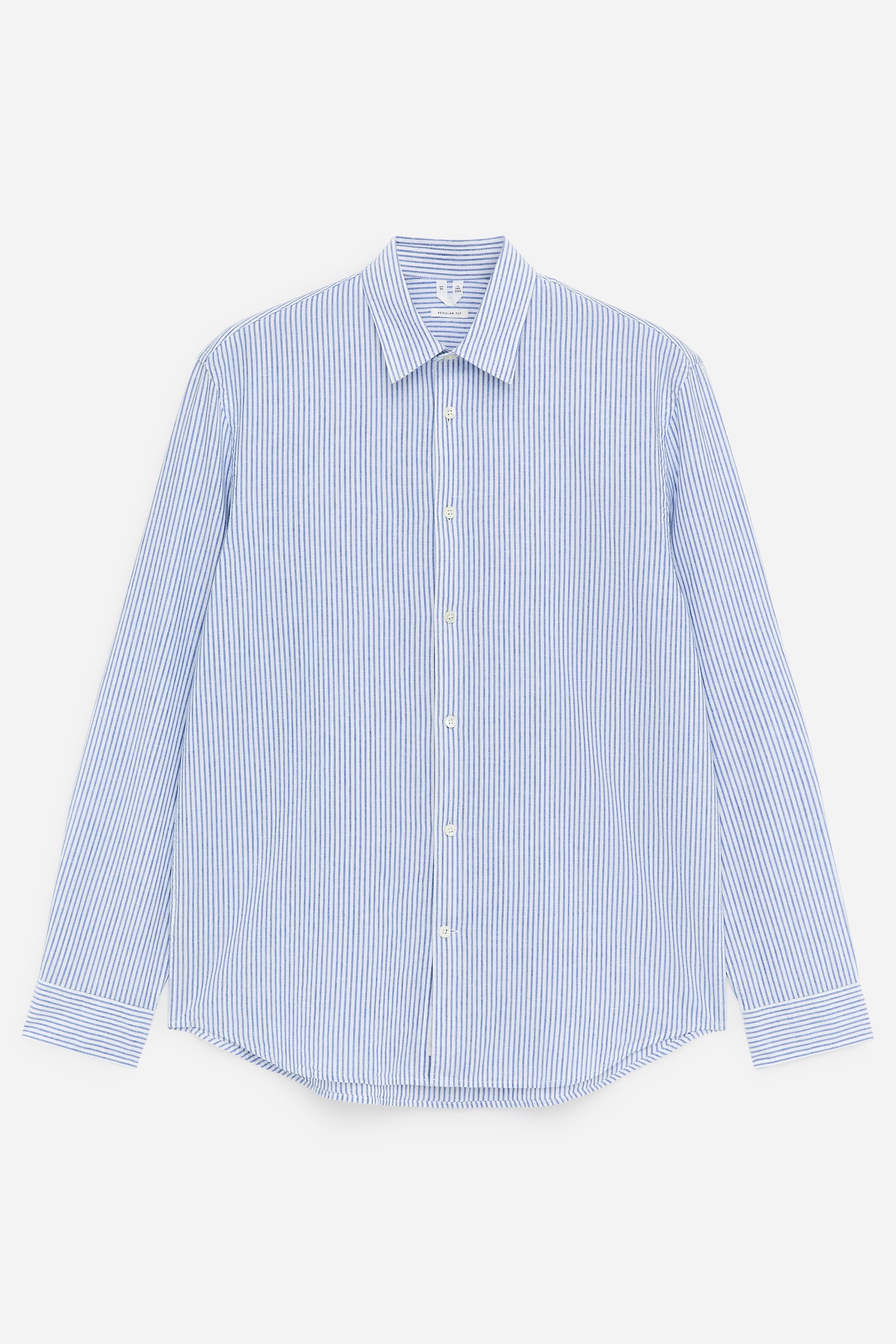 Une chemise à rayures bleues et blanches présente sa vue de face. Elle est dotée d'un col pointu, de manches longues avec poignets, et d'une fermeture boutonnée sur le devant avec des boutons blancs, se terminant par un ourlet arrondi.