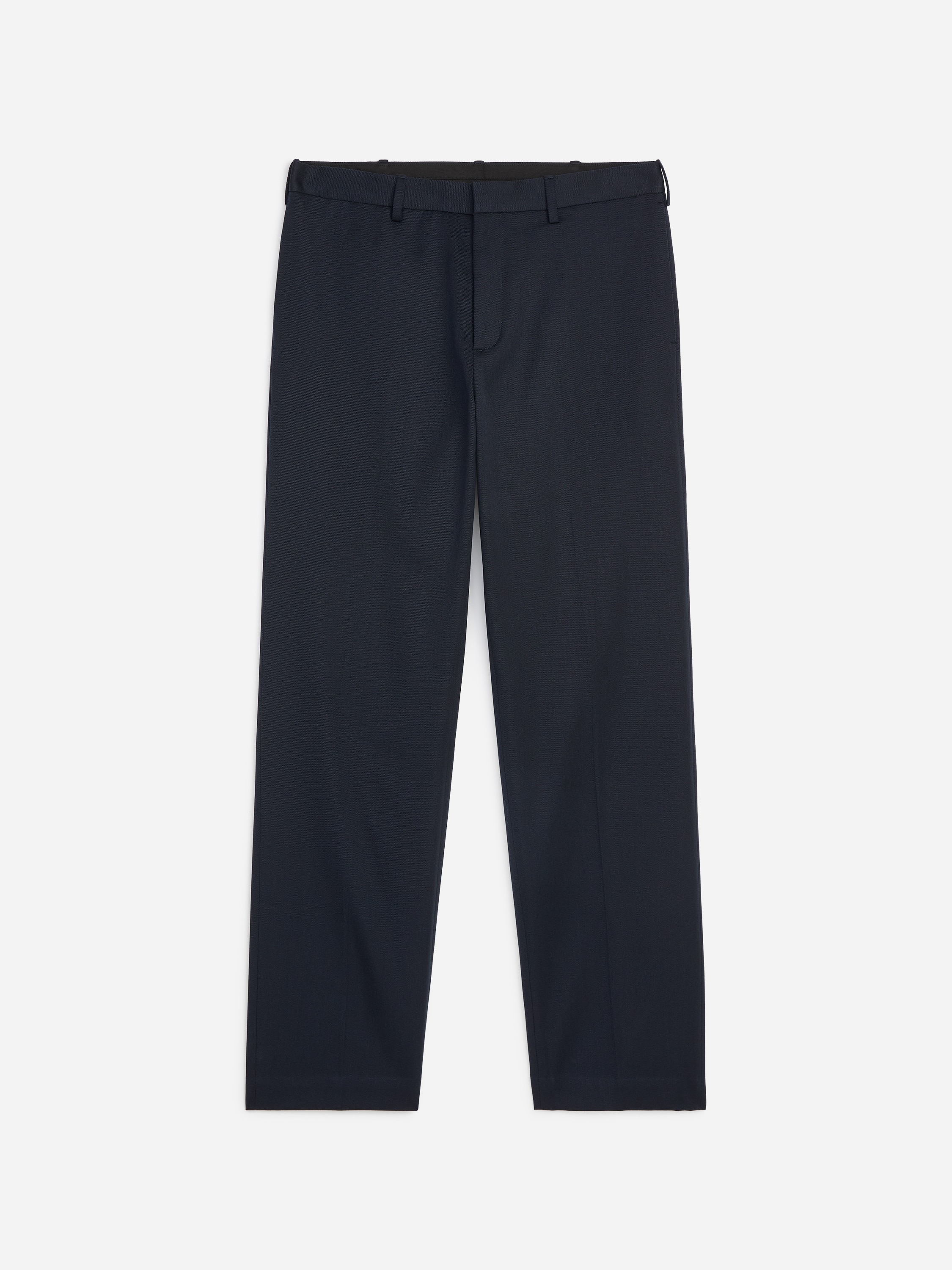 Le mannequin porte un pantalon en laine et coton dâune teinte bleu marine foncÃ©, dotÃ© dâune coupe droite et de plis marquÃ©s subtils. Le pantalon est associÃ© Ã  un pull col V marron foncÃ©, une chemise blanche Ã  col et des mocassins en cuir marron.