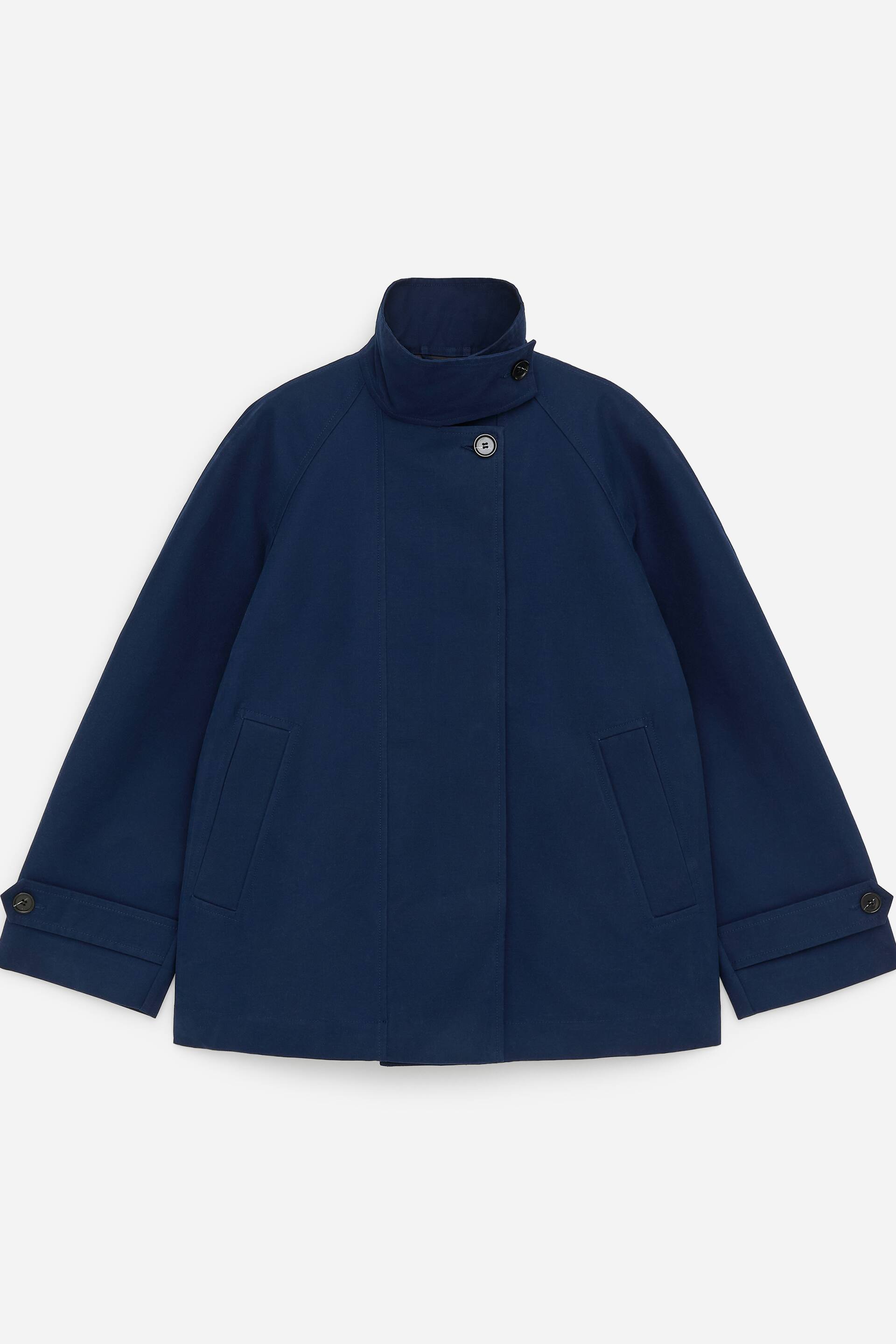 Grotere afbeelding bekijken: Een donkerblauw jasje wordt in vooraanzicht gepresenteerd, met een opstaande kraag met een asymmetrische knoopsluiting en een verborgen voorbies met een zichtbare knoop onder de kraag. Het toont twee schuine paspelzakken en lange mouwen met knoopsluiting aan de manchetten.