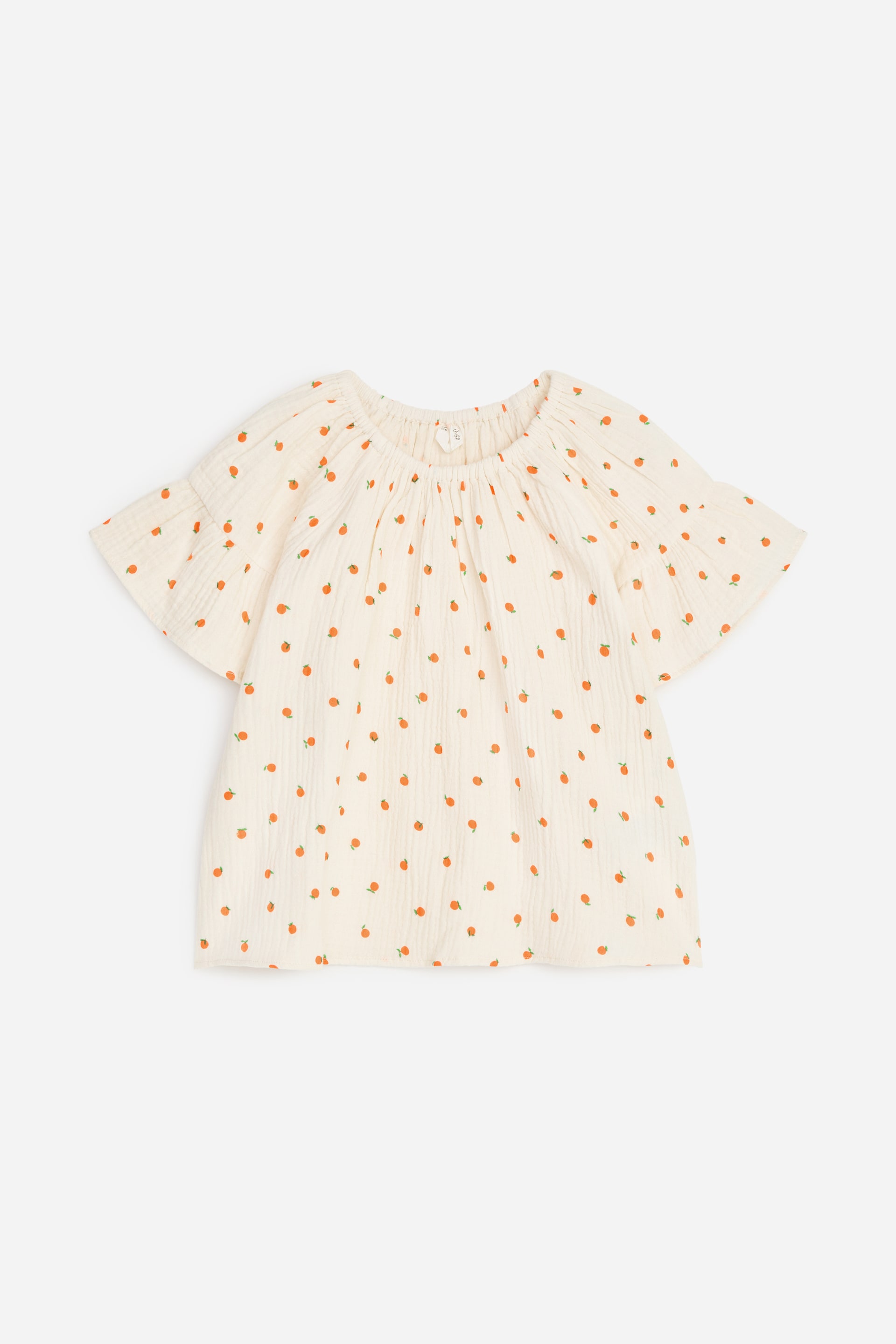 Grösseres Bild ansehen: Eine Bluse, gefertigt aus einem Baumwoll-Musselin-Gewebe, ist mit einem Allover-Print von kleinen orangefarbenen Früchten mit grünen Stielen verziert. Sie präsentiert sich im Pop-over-Stil mit einem elastischen Halsausschnitt, kurzen Ärmeln mit Rüschen-Details und einem lockeren Schnitt und wird von vorne gezeigt.