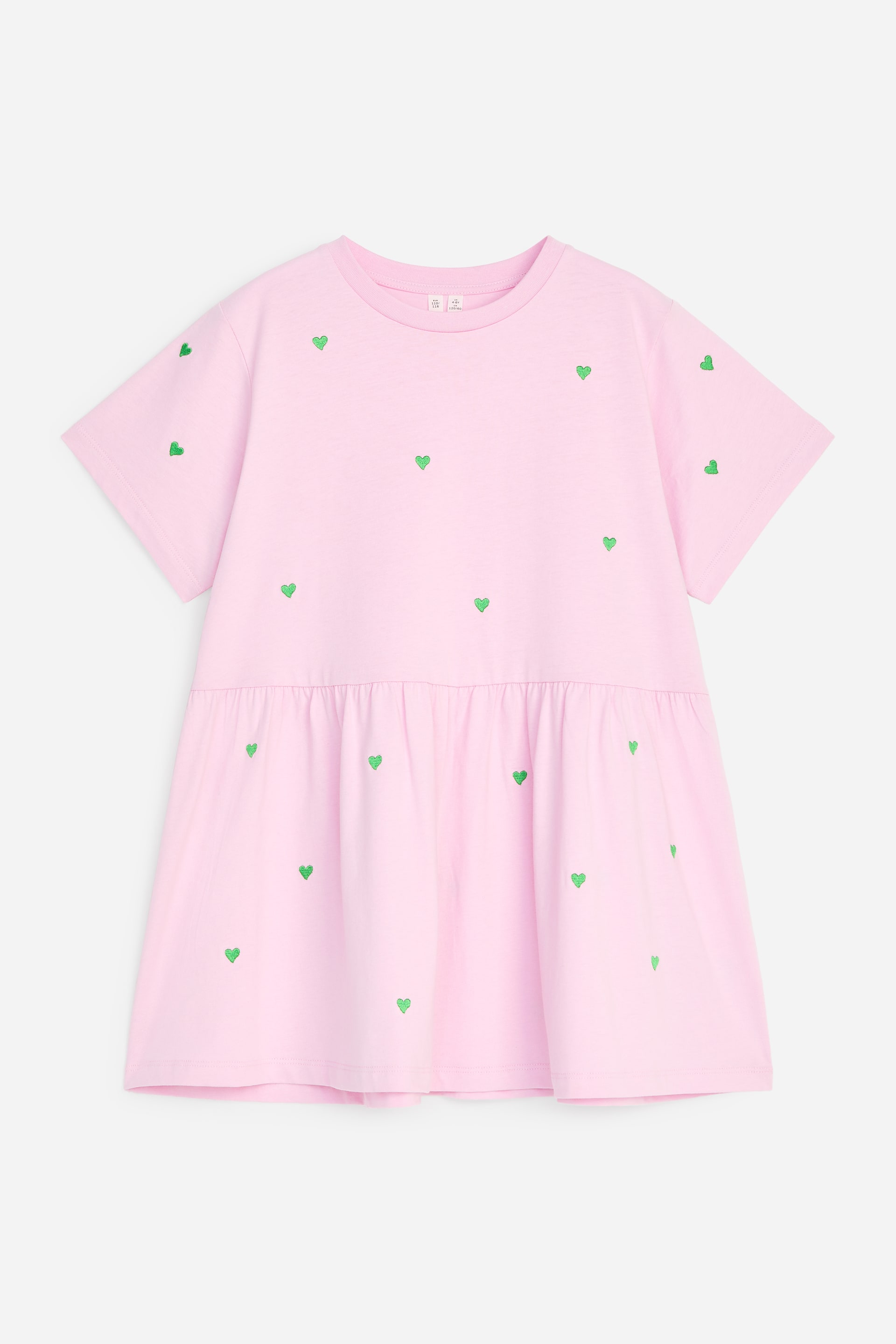 View larger image: The front of a pink short-sleeved dress features a round neck and a gathered seam at the waist, creating a tiered skirt. Green heart motifs are scattered across the entire dress.