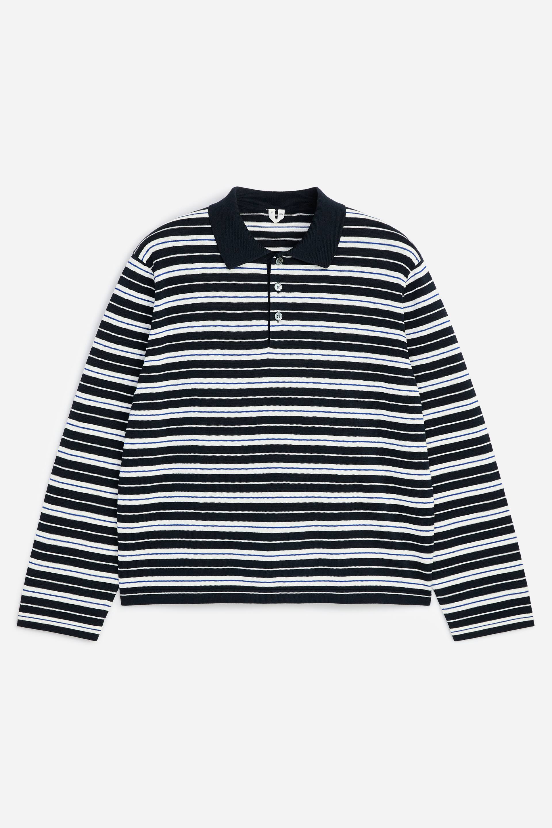 Grotere afbeelding bekijken: Een gebreide poloshirt met lange mouwen toont zwarte, witte en dunne blauwe horizontale strepen. Het is ontworpen met een geribbelde marineblauwe spreadkraag en een knoopsluiting met twee knopen aan de voorkant.