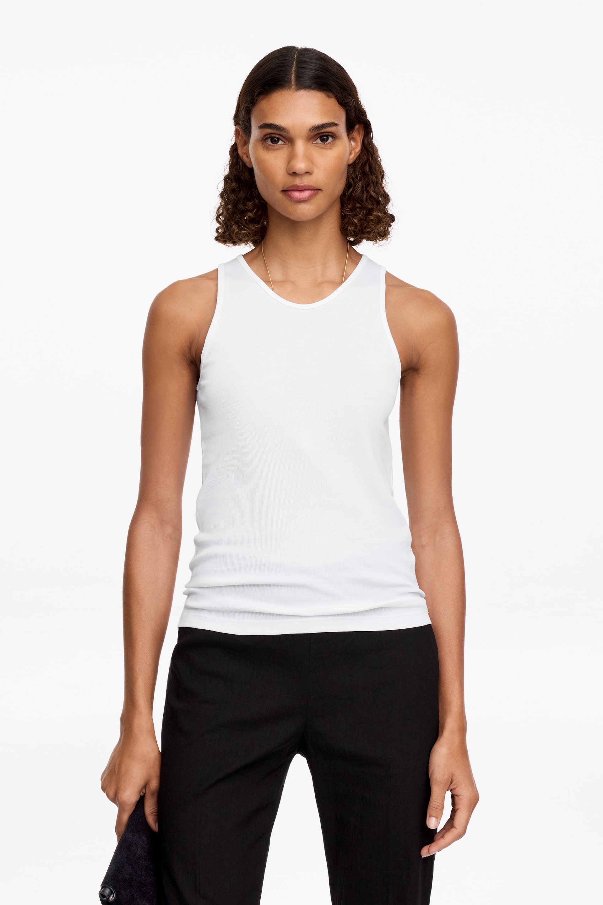Größeres Bild ansehen: Ein weißes geripptes Tanktop mit Rundhalsausschnitt und figurbetonter Silhouette, aus einem frontalen Winkel gezeigt.