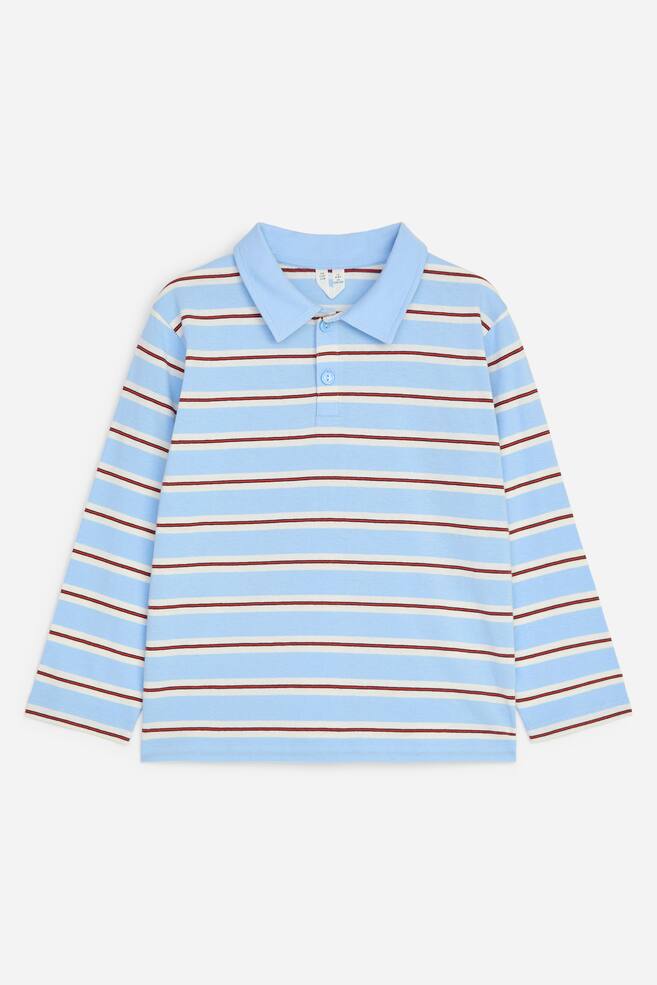 A long-sleeved polo shirt is laid flat, facing front, displaying a pattern of horizontal light blue, white and thin reddish-brown stripes. The shirt features a solid light blue collar, a two-button placket, and straight-cut cuffs and hem. - 1