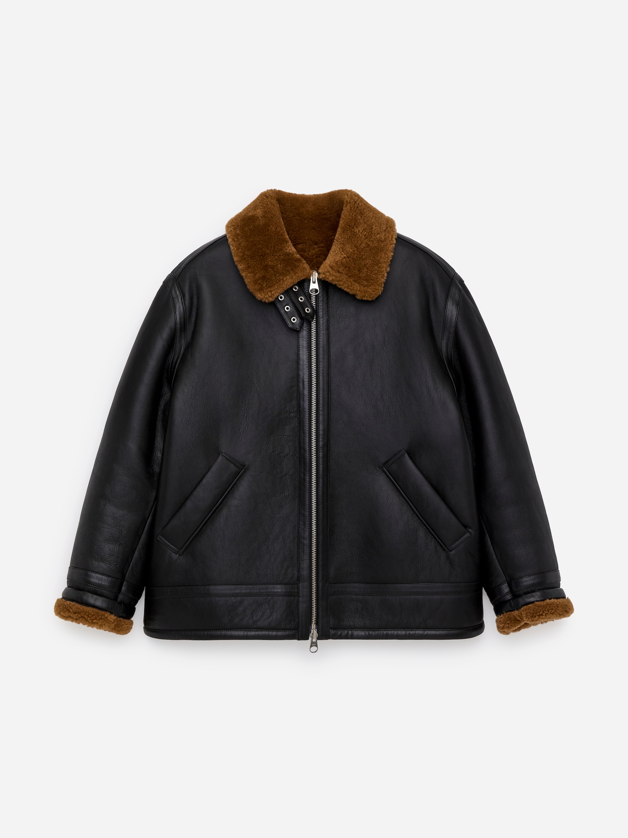 Agrandir l'image: Une veste en shearling noire surdimensionnée est présentée de FACE, avec un col en fourrure marron orné de deux sangles réglables et de boucles en métal. Elle est également dotée d'une fermeture éclair bidirectionnelle à l'avant, de deux poches à rabat en biais et d'une doublure en fourrure marron visible aux poignets.