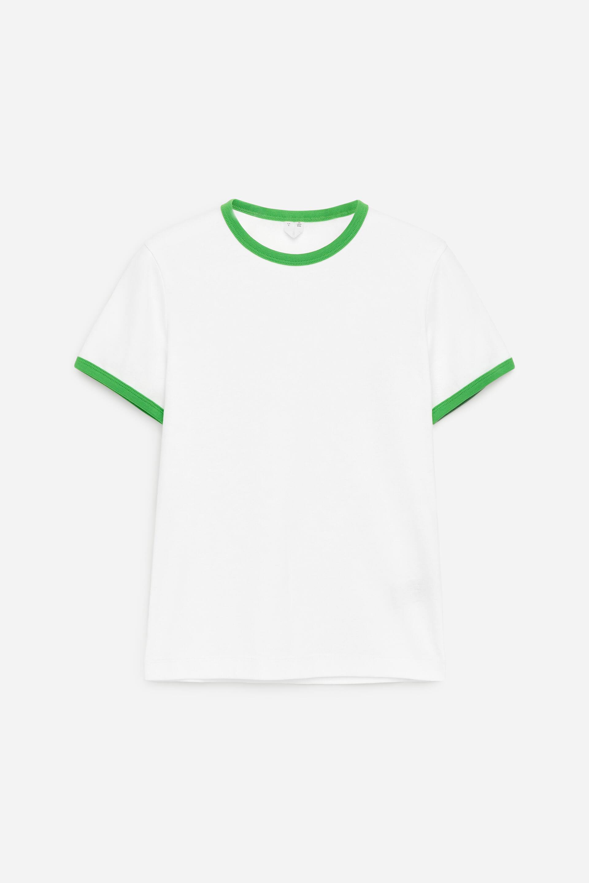 Ver imagen más grande: Una camiseta blanca presenta su vista frontal, mostrando mangas cortas y un cuello redondo, ambos detallados con un ribete de contraste verde. Se caracteriza por un ajuste entallado y está confeccionada con suave algodón acanalado.