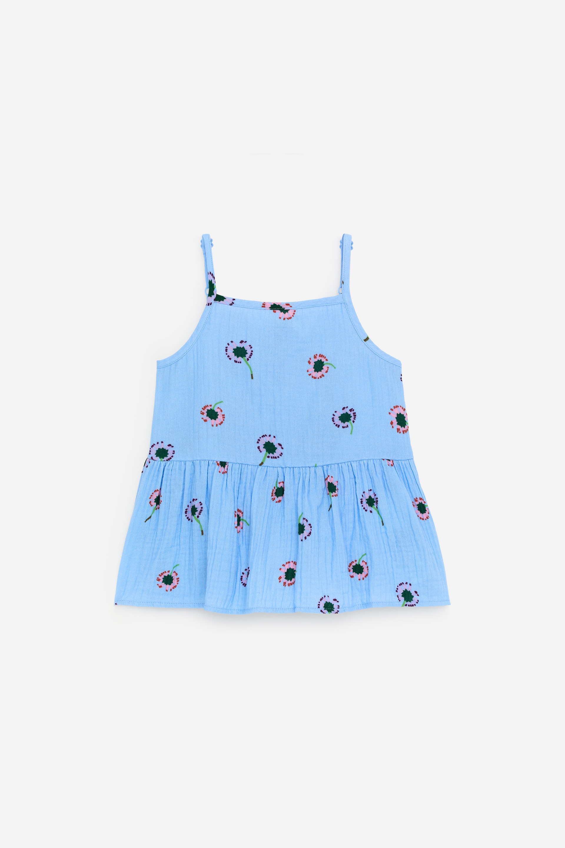 Grotere afbeelding bekijken: Een lichtblauw gekreukt camisole-topje toont een patroon van gestileerde roze en paarse bloemen met groene harten. Het heeft dunne schouderbandjes en een rechte halslijn, met een ontspannen pasvorm die zich verzamelt in een gerimpelde laag aan de onderkant.