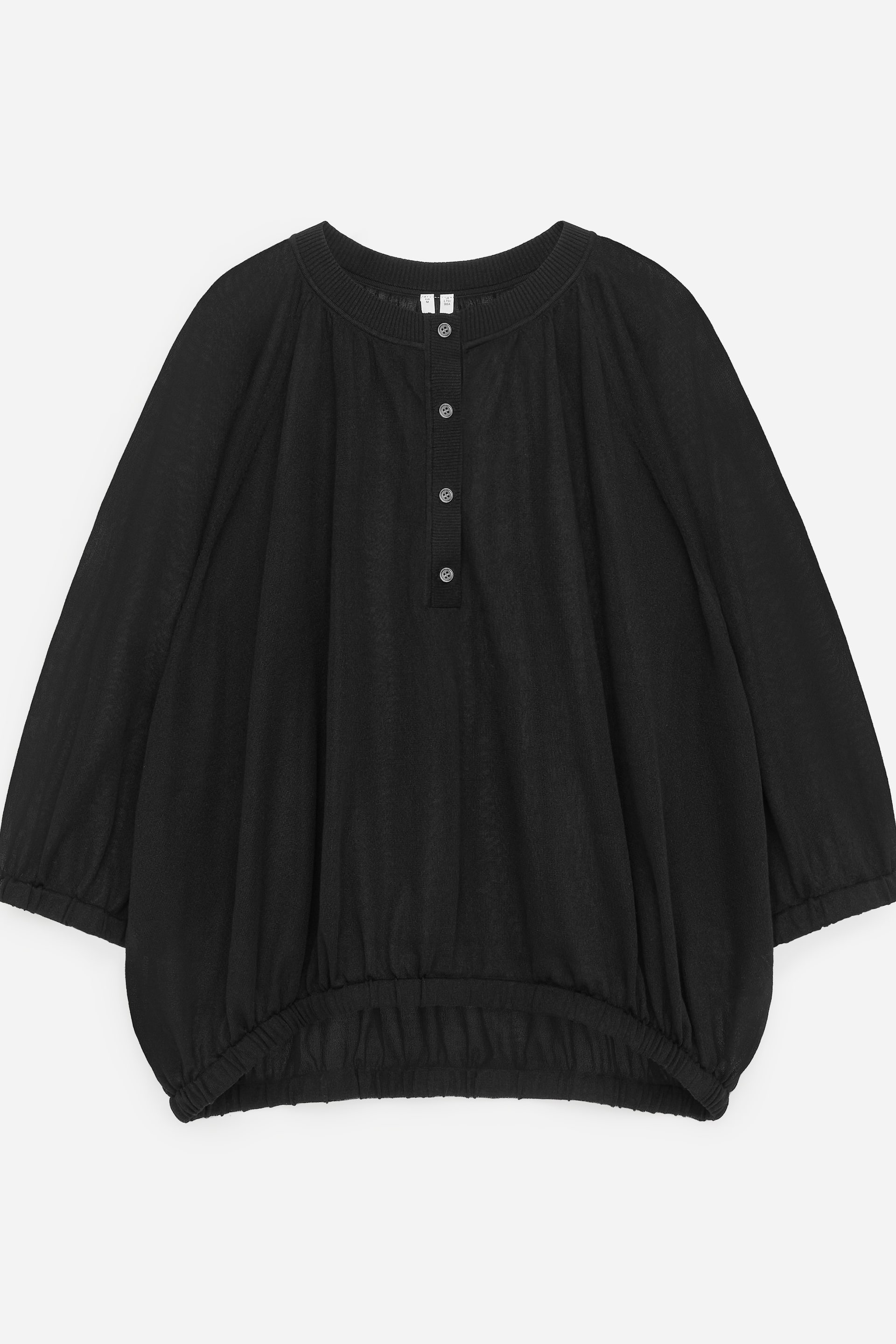 Visualizza immagine più grande: Un top nero in maglia leggera presenta il suo fronte, caratterizzato da uno scollo rotondo a coste e un'abbottonatura henley a cinque bottoni. È progettato con maniche raglan voluminose e un orlo inferiore elasticizzato che crea una silhouette a blusa.