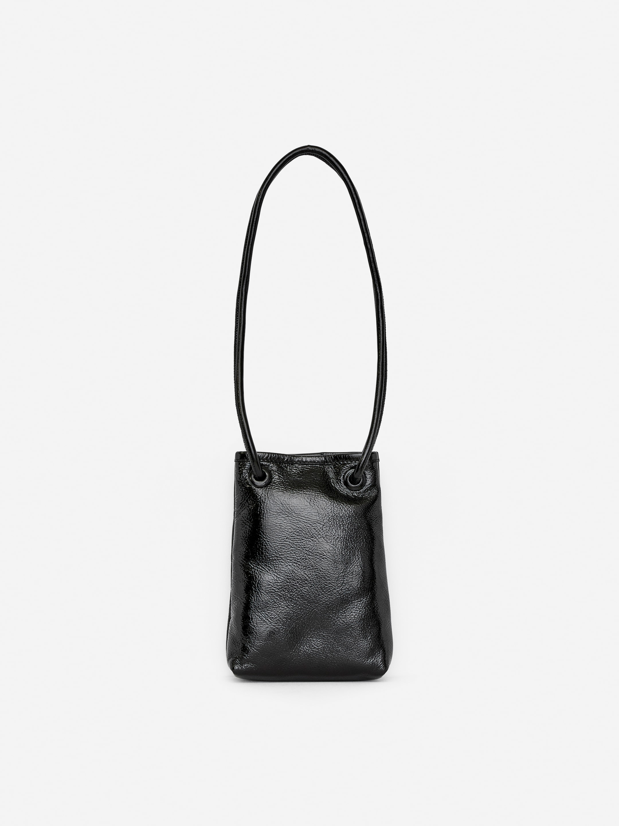 Visa större bild: En svart läder crossbody-väska visar sin framsida. Den har en rektangulär kropp med en glänsande, texturerad yta, och en tunn, rörformad axelrem är ansluten till väskan via två läderklädda öljetter.