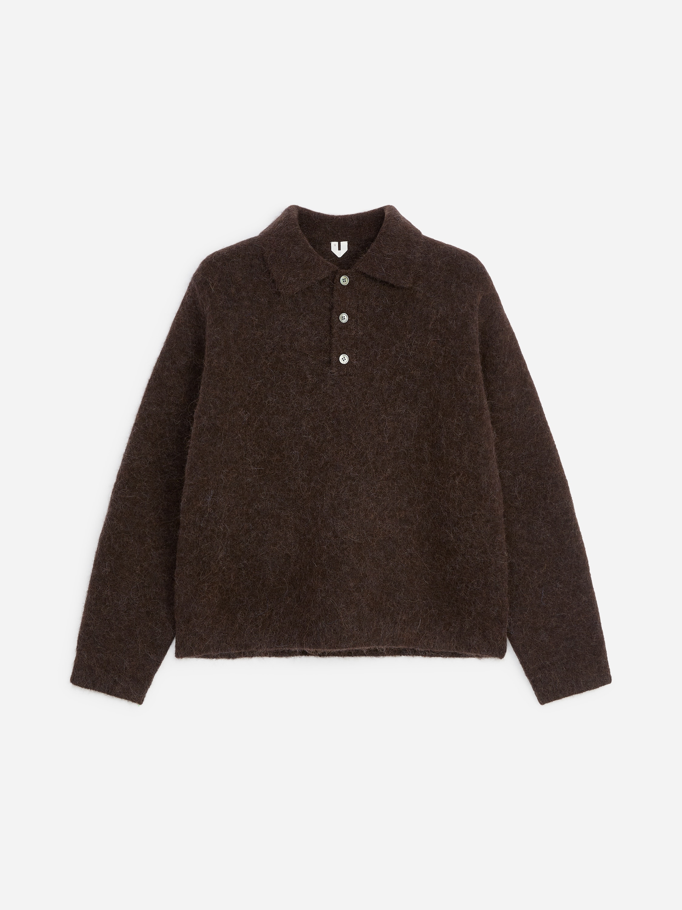 Model ma na sobie ciemnobrÄzowy, puszysty sweter polo z dzianiny, z koÅnierzykiem i zapiÄciem na trzy guziki. Sweter jest zaÅoÅ¼ony na jasnoniebieskÄ koszulÄ zapinanÄ na guziki i zestawiony z beÅ¼owymi spodniami.