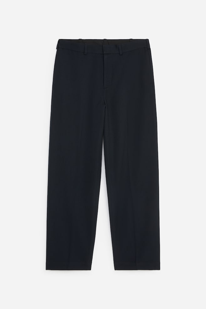 These dark navy trousers are hung in a front-facing view, showing a straight-leg silhouette, a structured waistband with belt loops, and a concealed front fastening. - 1