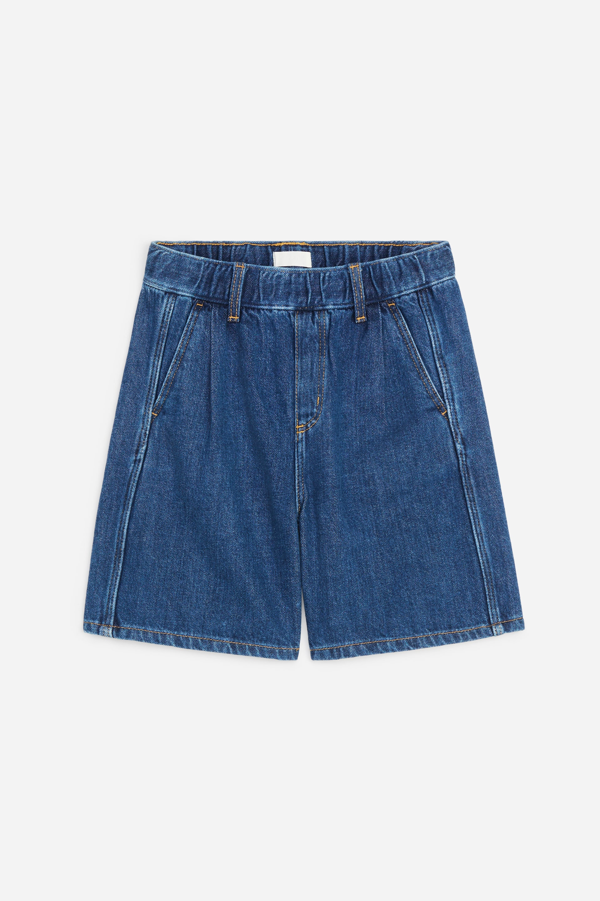 Agrandir l'image: Les shorts en denim sont présentés en vue de face, avec une taille élastiquée dotée de passants pour ceinture, une fausse braguette et des poches avant inclinées. Des coutures verticales proéminentes détaillent le design à jambes larges, qui se termine par un ourlet droit.