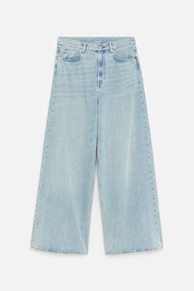CEDAR Oversized Wide Jeans present themselves from the front in a light blue wash, highlighting a relaxed, wide-leg cut. The jeans feature a button and zip fly fastening, with front and coin pockets. - 1