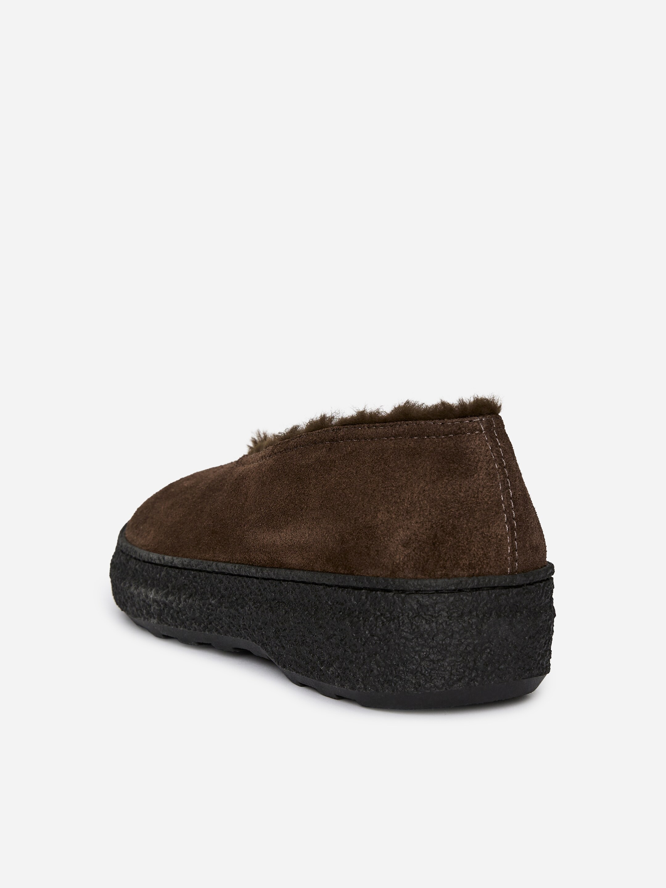 Agrandir l'image: Une chaussure en daim marron est dotée d'une semelle noire épaisse et texturée. Une doublure en fourrure marron foncé est visible autour de l'ouverture, avec des coutures de couleur claire détaillant le talon, présentée en vue arrière trois-quarts.