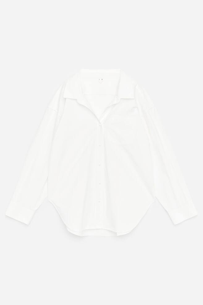 Una camicia bianca a maniche lunghe è presentata frontalmente (FRONTE), con colletto a punta, chiusura con bottoni a tutta lunghezza e una singola tasca applicata sul lato sinistro del petto. È realizzata con maniche lunghe, polsini abbottonati e orlo stondato, e presenta una vestibilità comoda. - 1