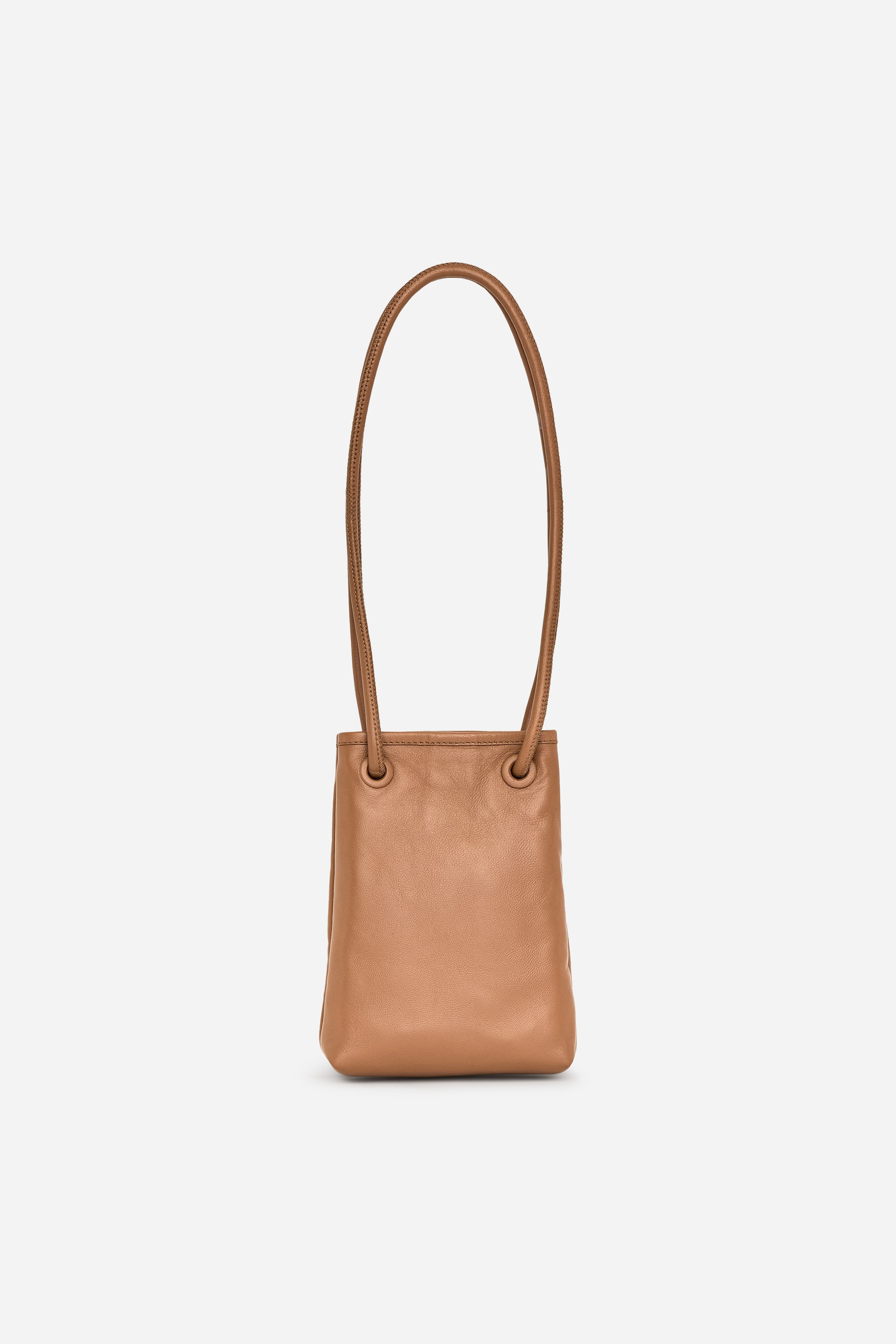 Visualizza l'immagine ingrandita: Una borsa a tracolla color cuoio, realizzata in pelle conciata senza cromo, è rivolta frontalmente. Le cinghie a spalla tubolari passano attraverso occhielli rivestiti in pelle nella parte superiore.