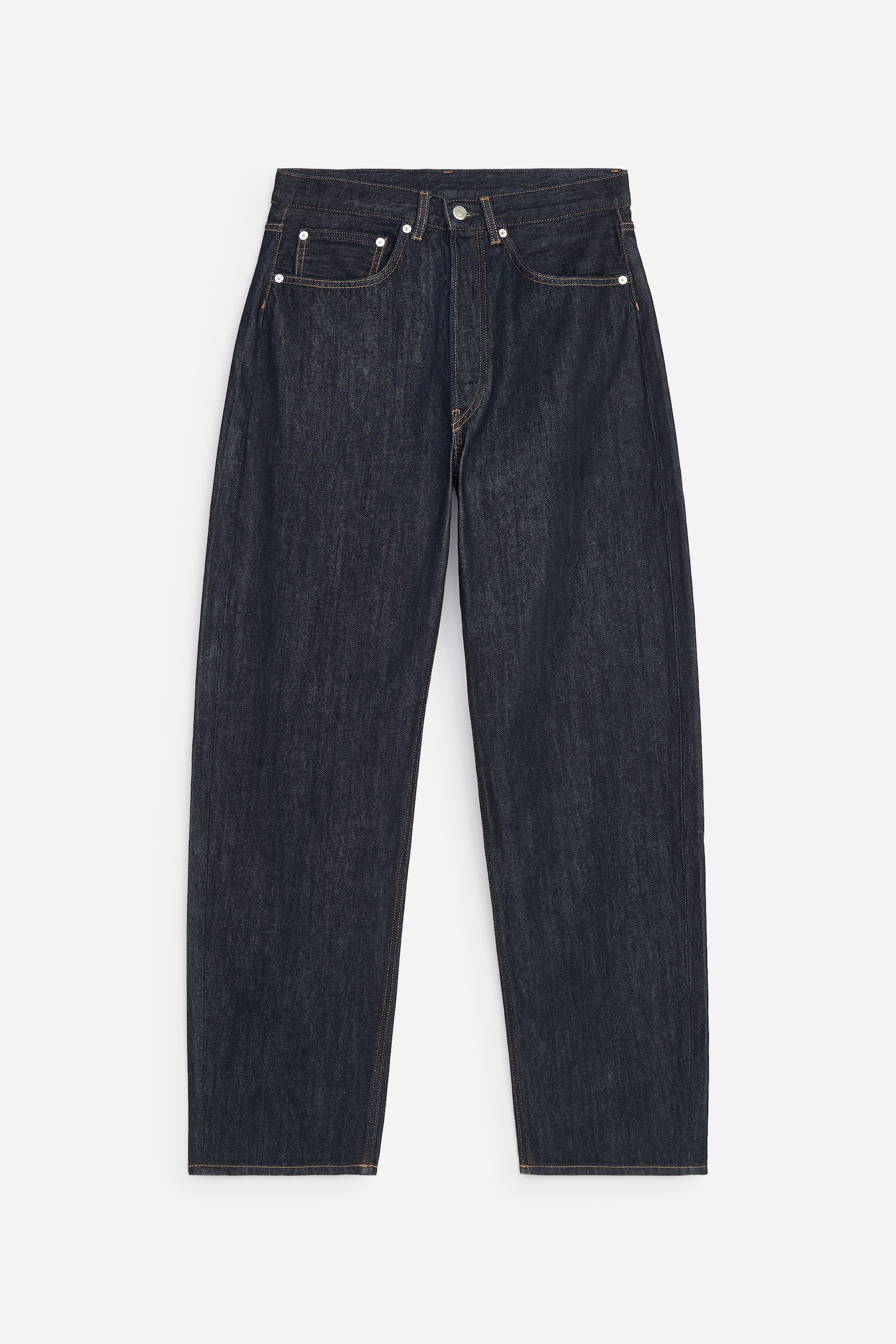 Et par mÃ¸rkvaskede indigoblÃ¥ denimjeans er vist forfra og har en afslappet pasform med tÃ¸ndeformede ben og en mellemhÃ¸j talje. Jeansen har klassisk femlommestil med orange kontrastsyninger og nitter i sÃ¸lvfarvet metal.