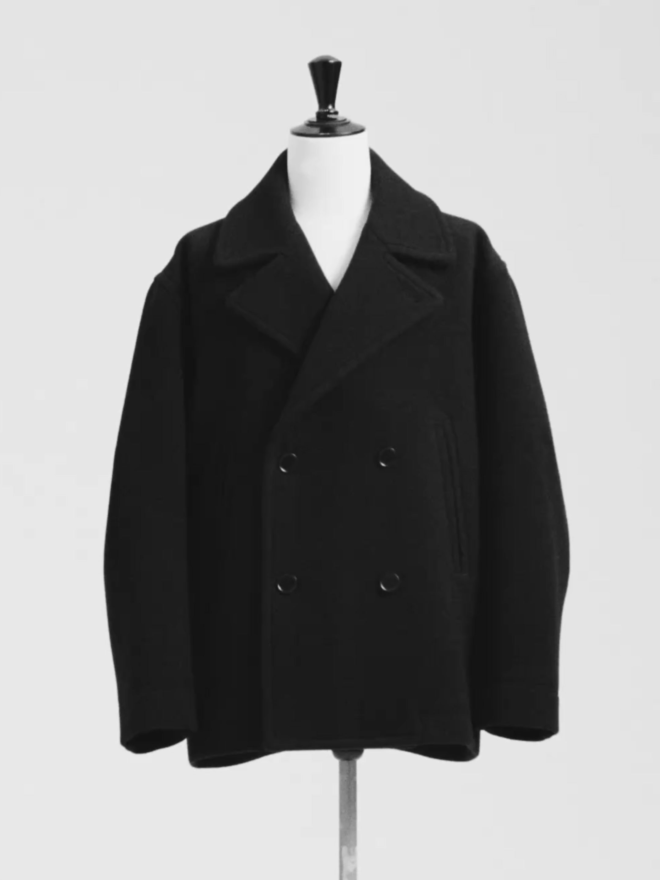Black double-breasted peacoat on a mannequin against a plain background.