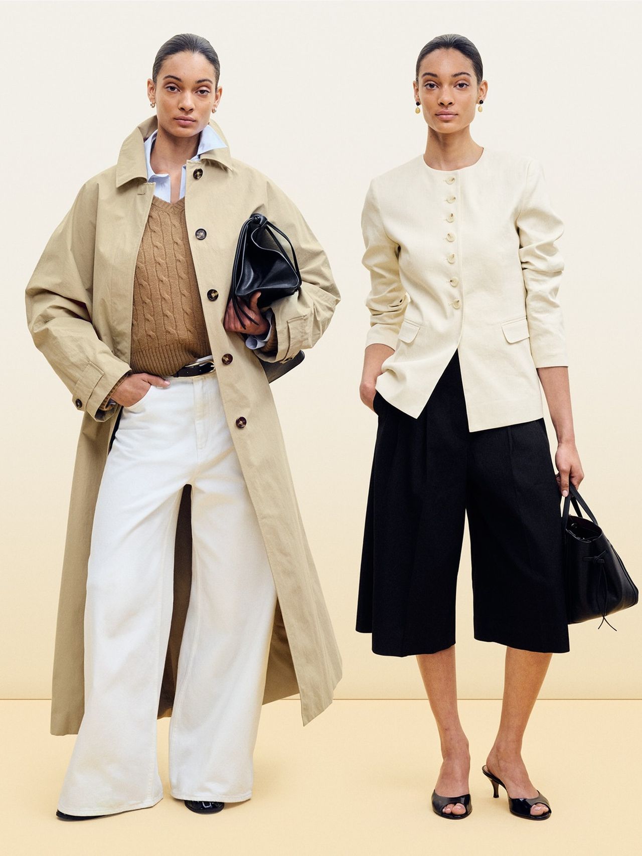 Two women pose in stylish outfits against a neutral background. One wears a trench coat and wide pants; the other, a buttoned jacket and culottes.
