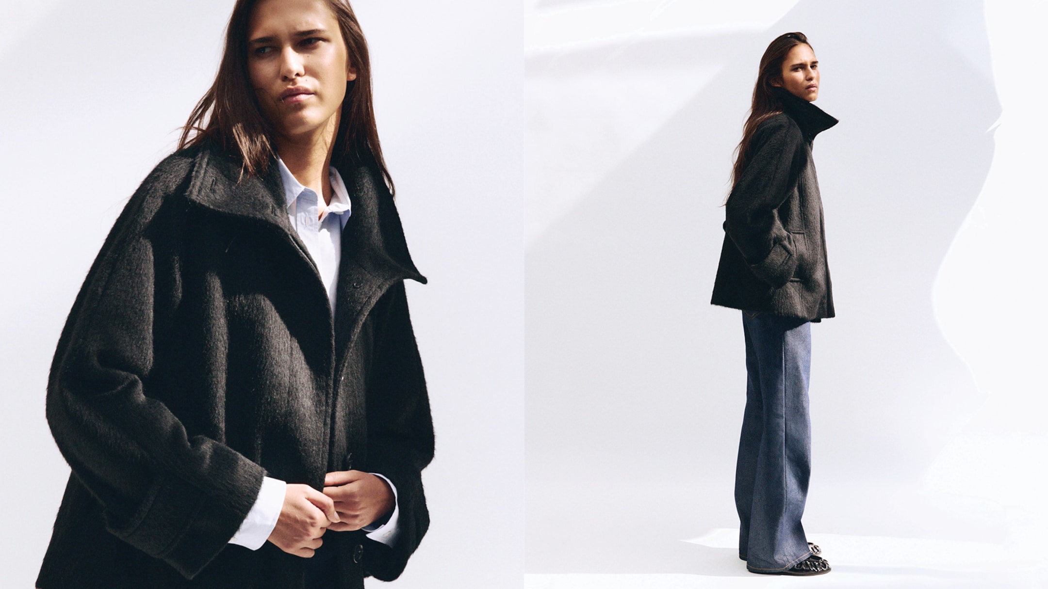 A woman in a dark coat and blue jeans poses against a bright background, looking forward with a thoughtful expression.