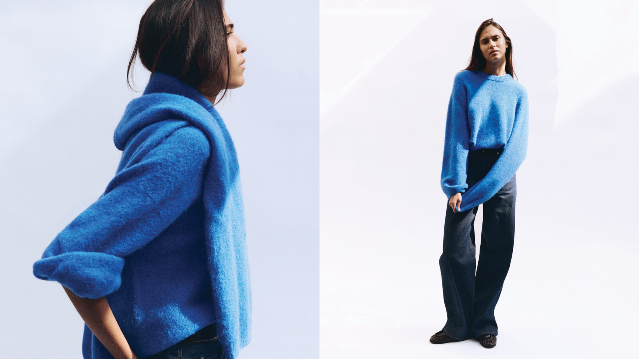 A person in a blue sweater poses with relaxed posture. The sweater is textured and paired with dark wide-leg pants against a light background.