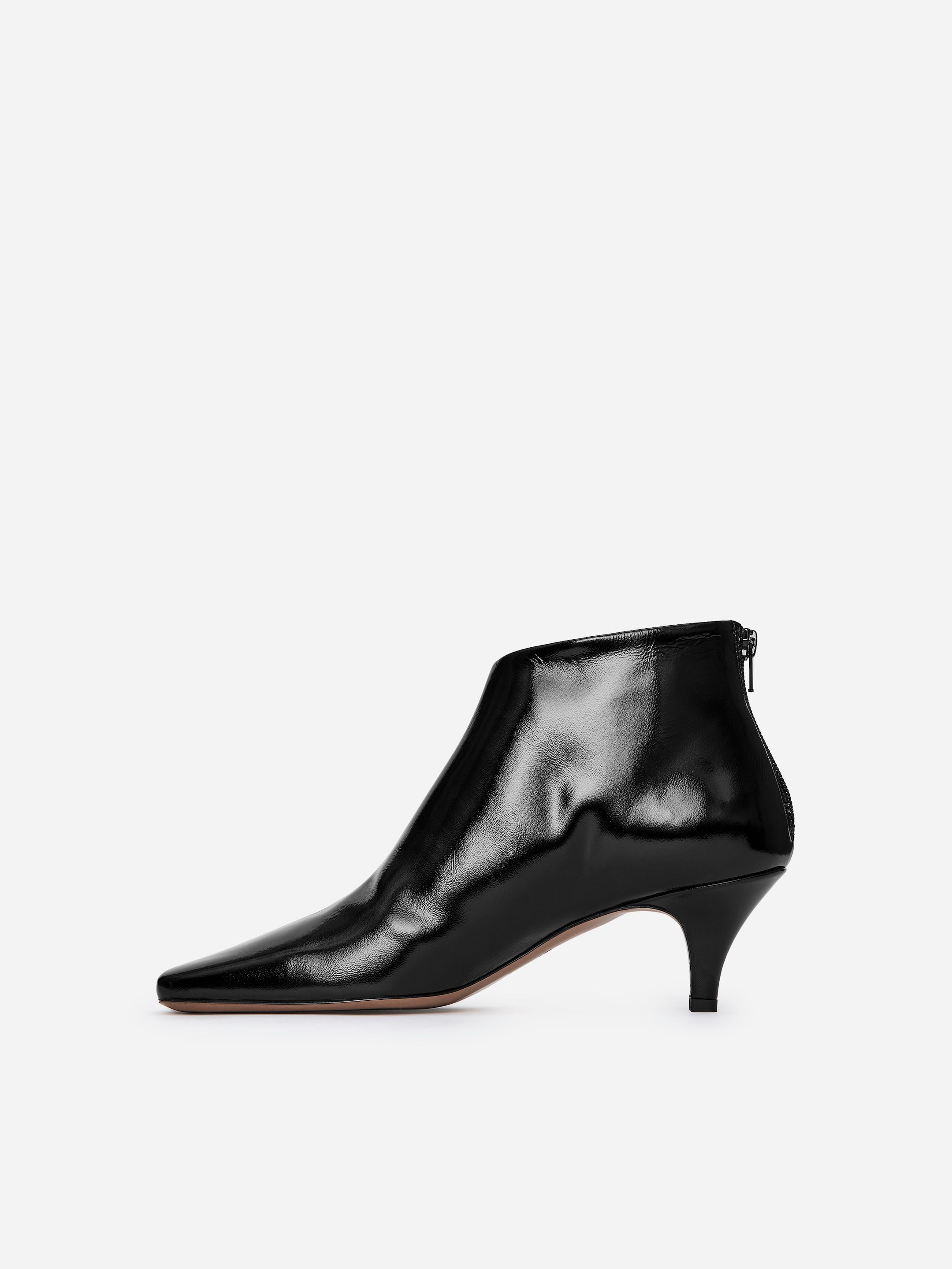 Black patent leather ankle boot with a pointed toe and mid-height heel, featuring a side zipper on a white background.