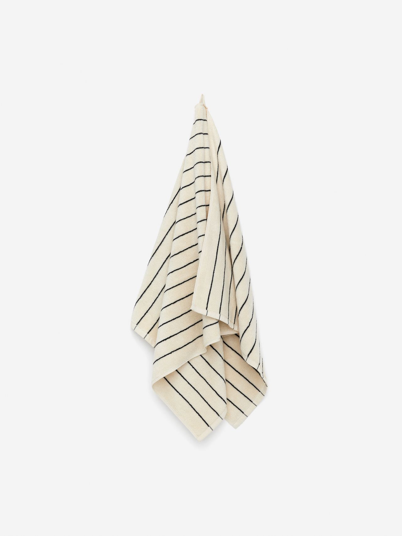 A cream-colored towel with thin black diagonal stripes hangs against a plain white background.
