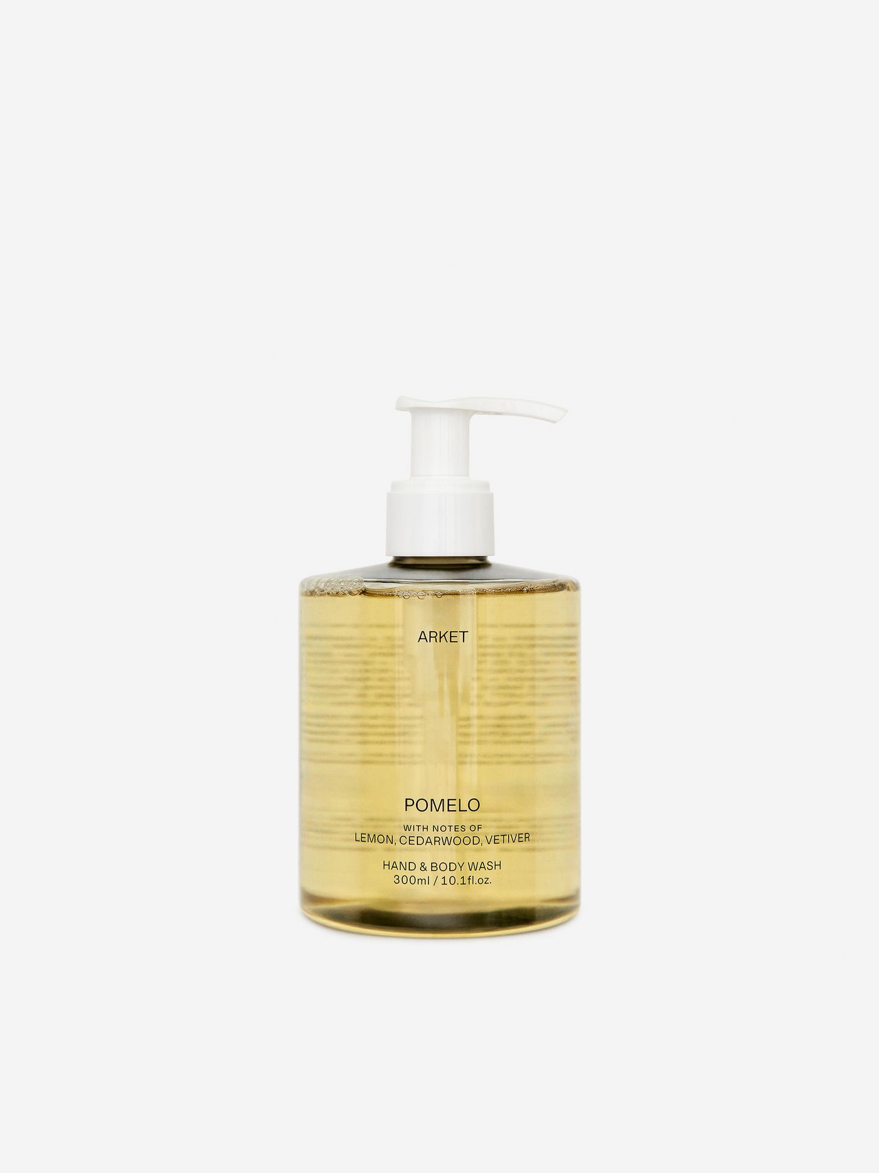 Clear bottle of Arket Pomelo hand and body wash with a pump dispenser, containing yellow liquid. Text on label describes scent and volume.