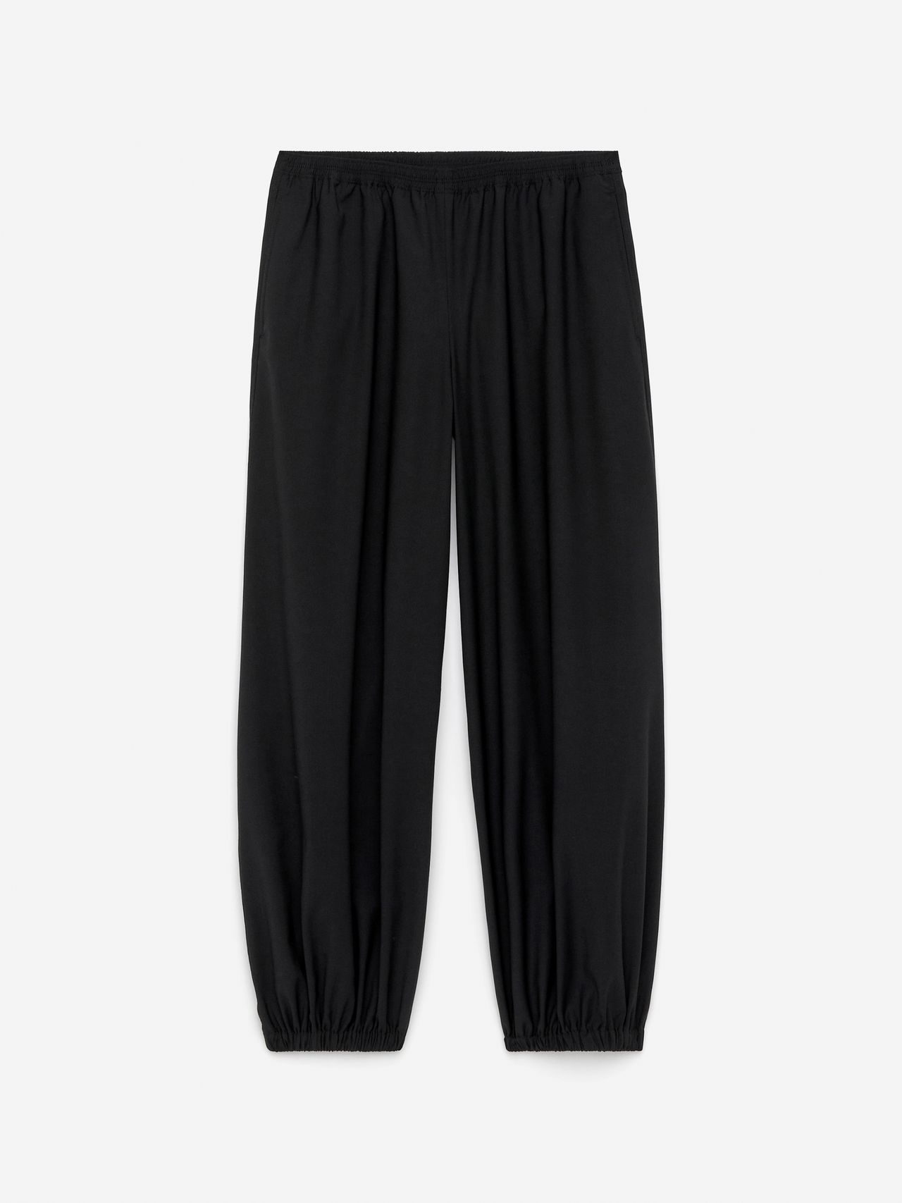 Black, loose-fitting pants with an elastic waistband and cuffs, laid flat against a white background.
