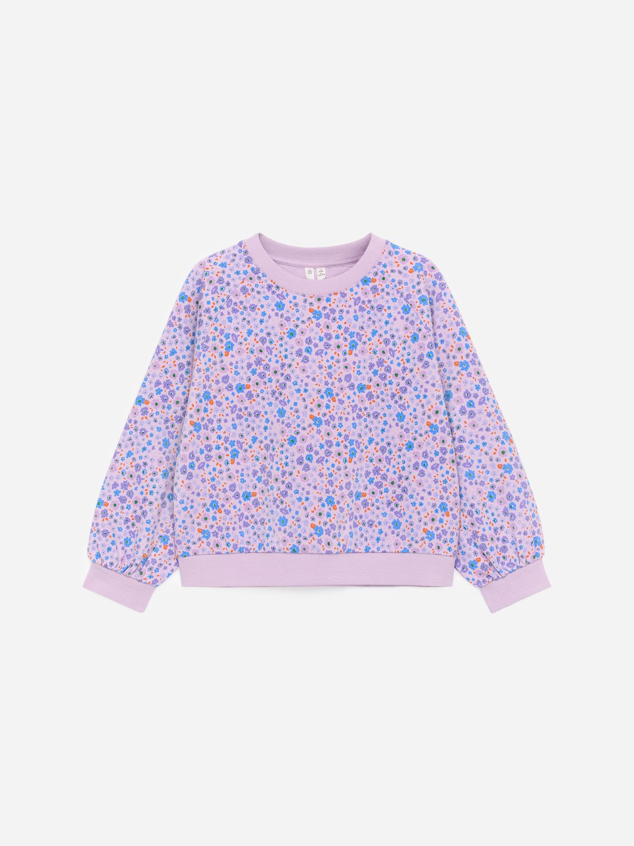 Lavender sweater with colorful floral pattern and ribbed cuffs and hem, displayed on a plain white background.