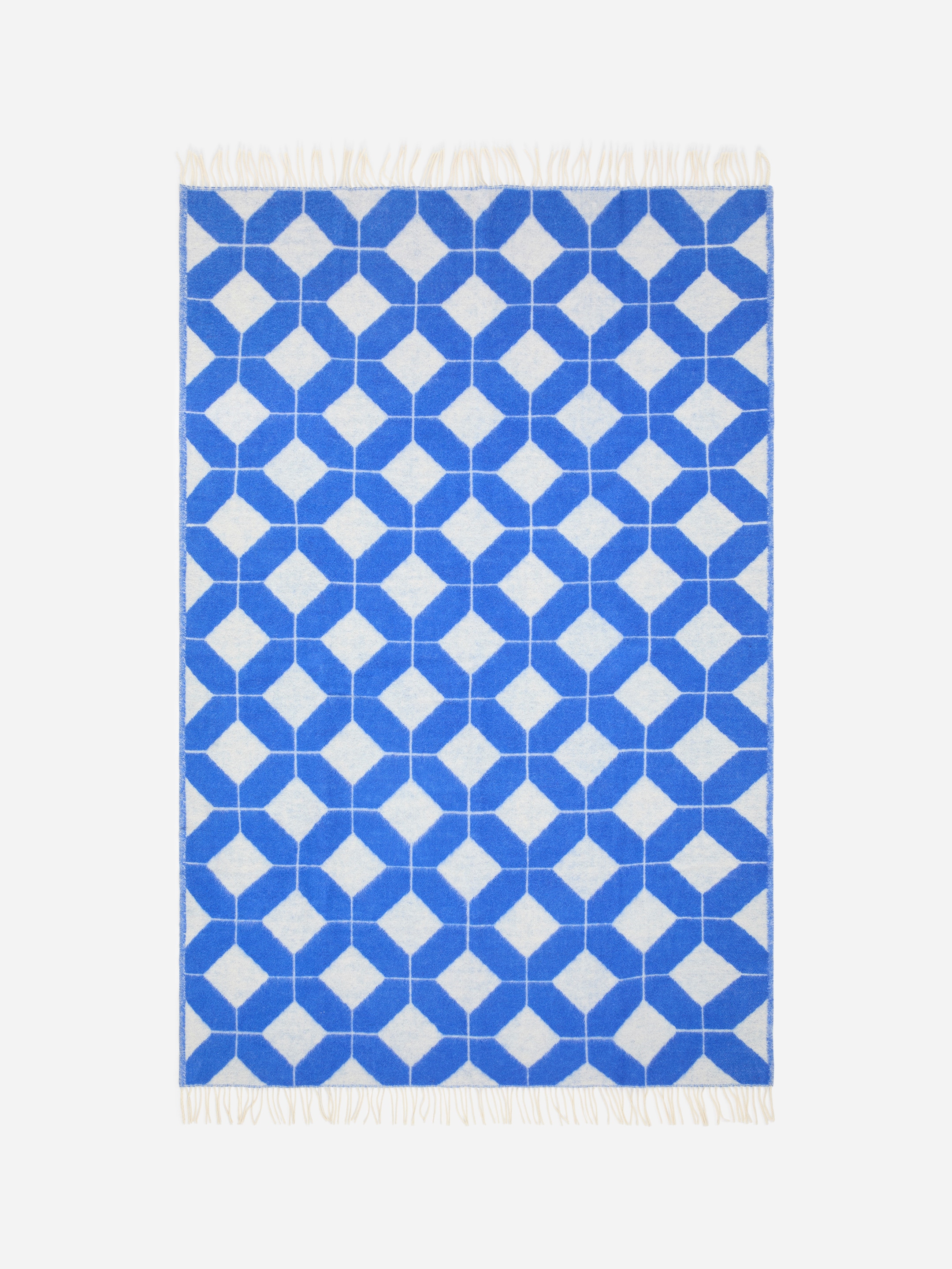 A blue and white geometric patterned blanket with fringe on the top and bottom edges.