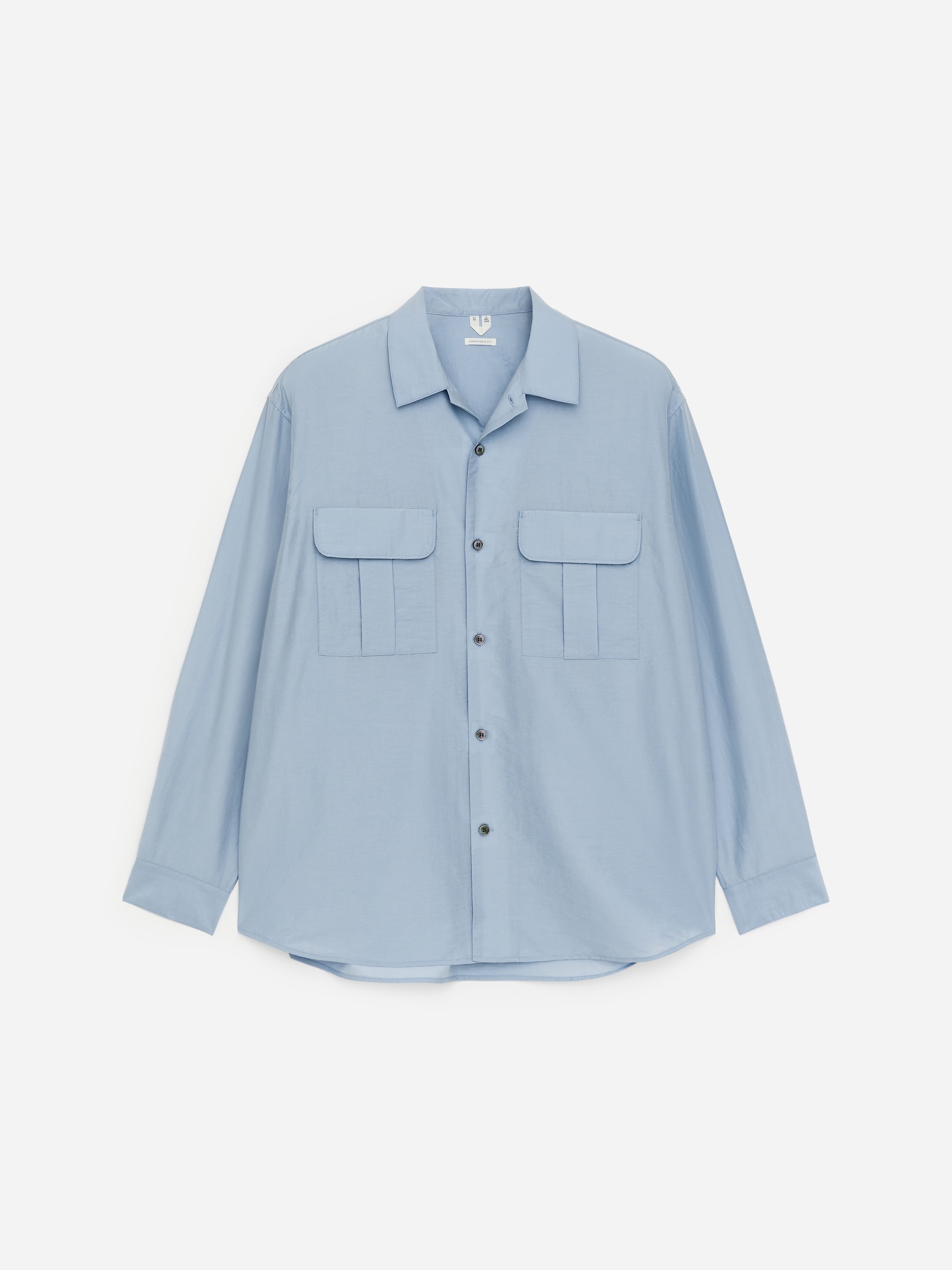 Light blue long-sleeve button-up shirt with two chest pockets, displayed against a white background.