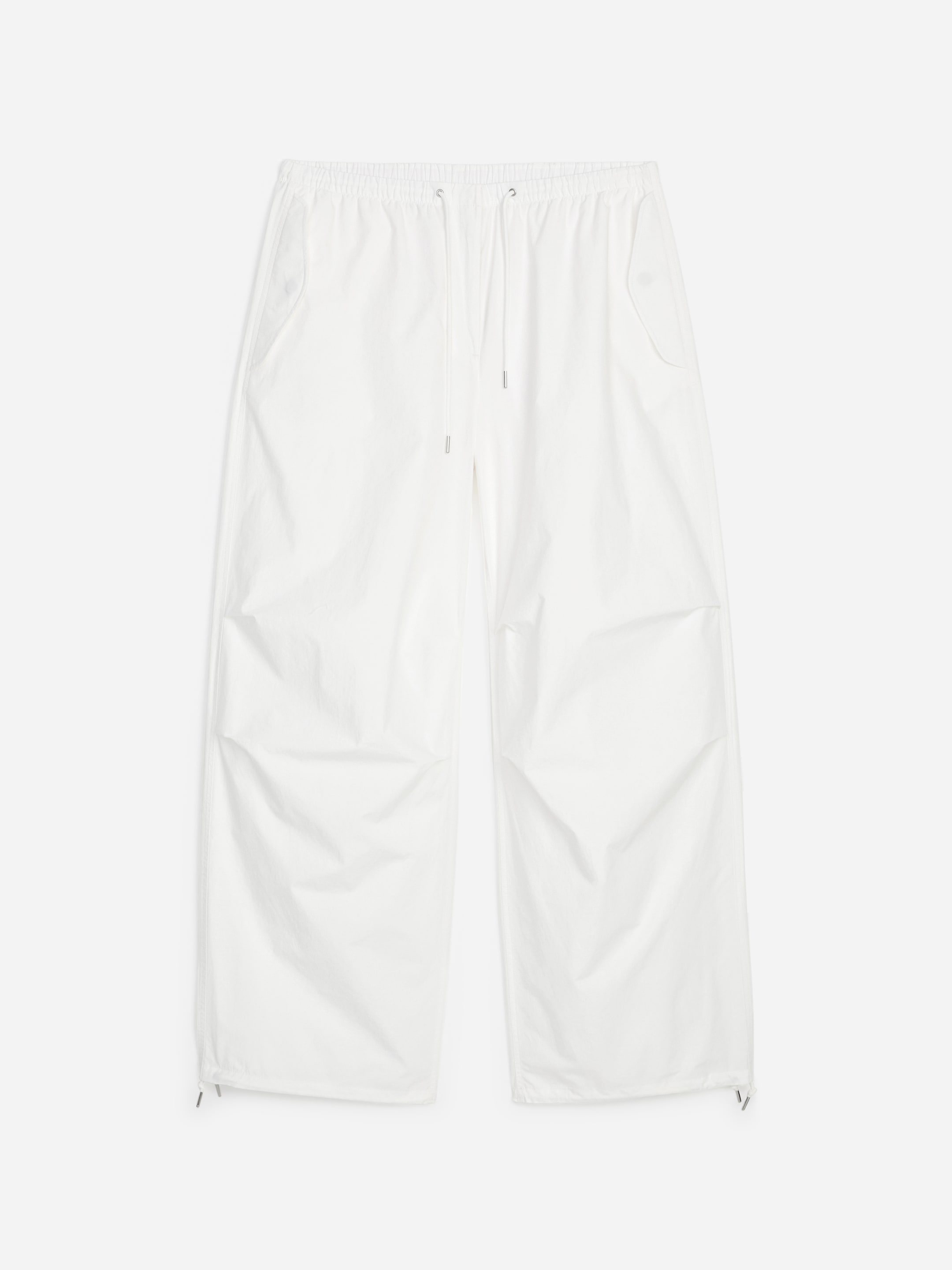 White wide-leg pants with an elastic waistband and drawstring. Features side pockets and subtle creasing, against a plain background.