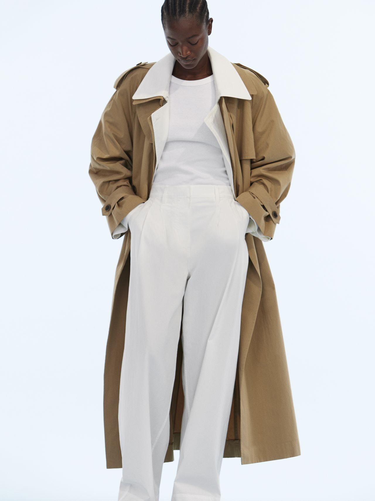 Woman in coat and white pants