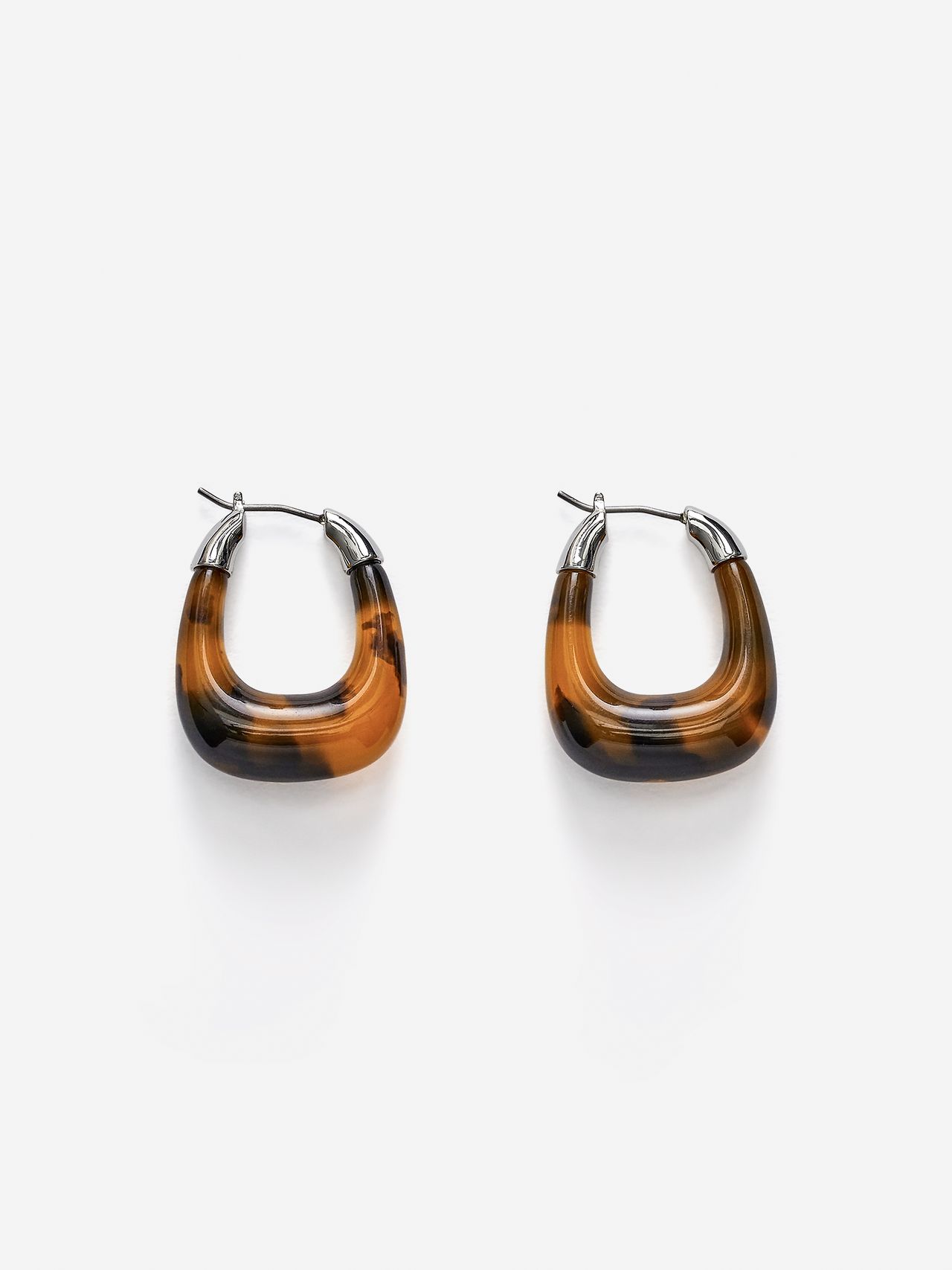 Two oval-shaped earrings with a gradient brown and black pattern with silver metal accents, set against a plain white background.