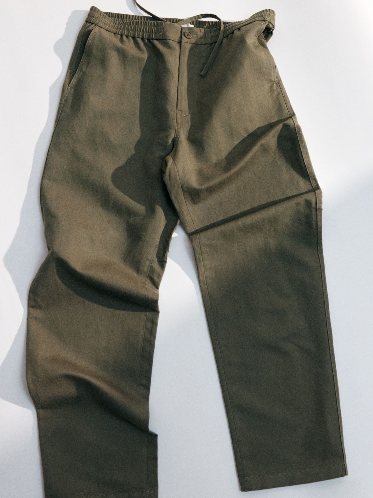 Olive green cargo pants with an elastic waistband and drawstring, laid flat on a light background.