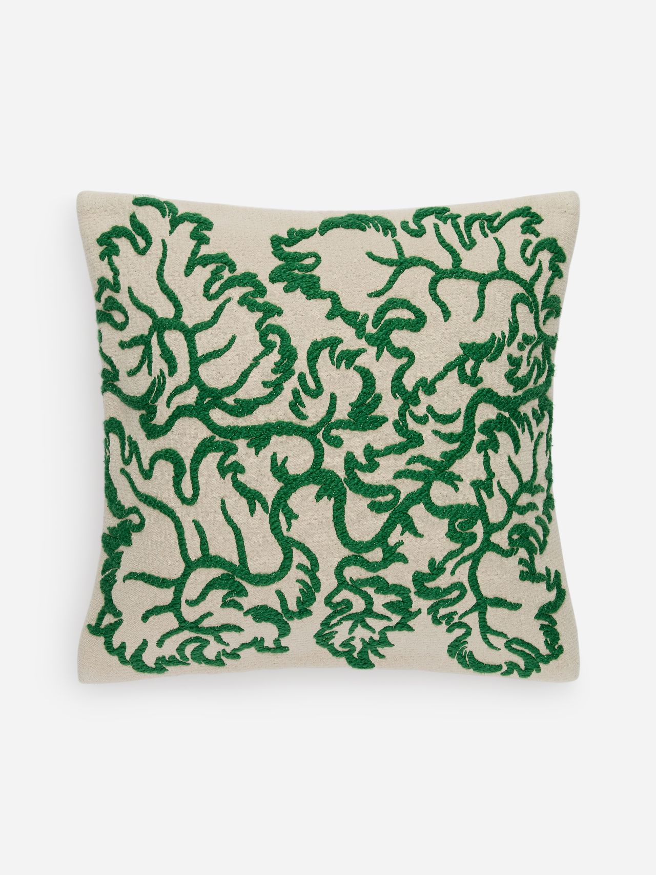 Beige cushion with intricate green embroidery featuring abstract floral patterns.