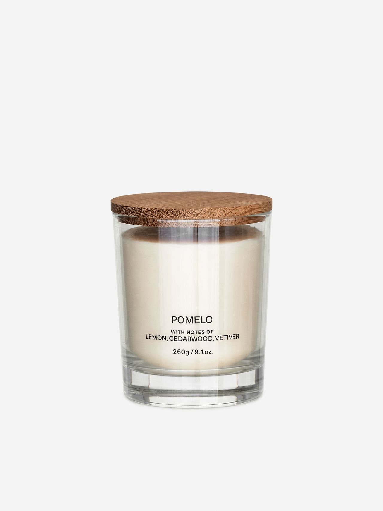 Glass jar candle with wooden lid, labeled "POMELO" and notes of lemon, cedarwood, vetiver. Weight: 260g, 9.1oz.